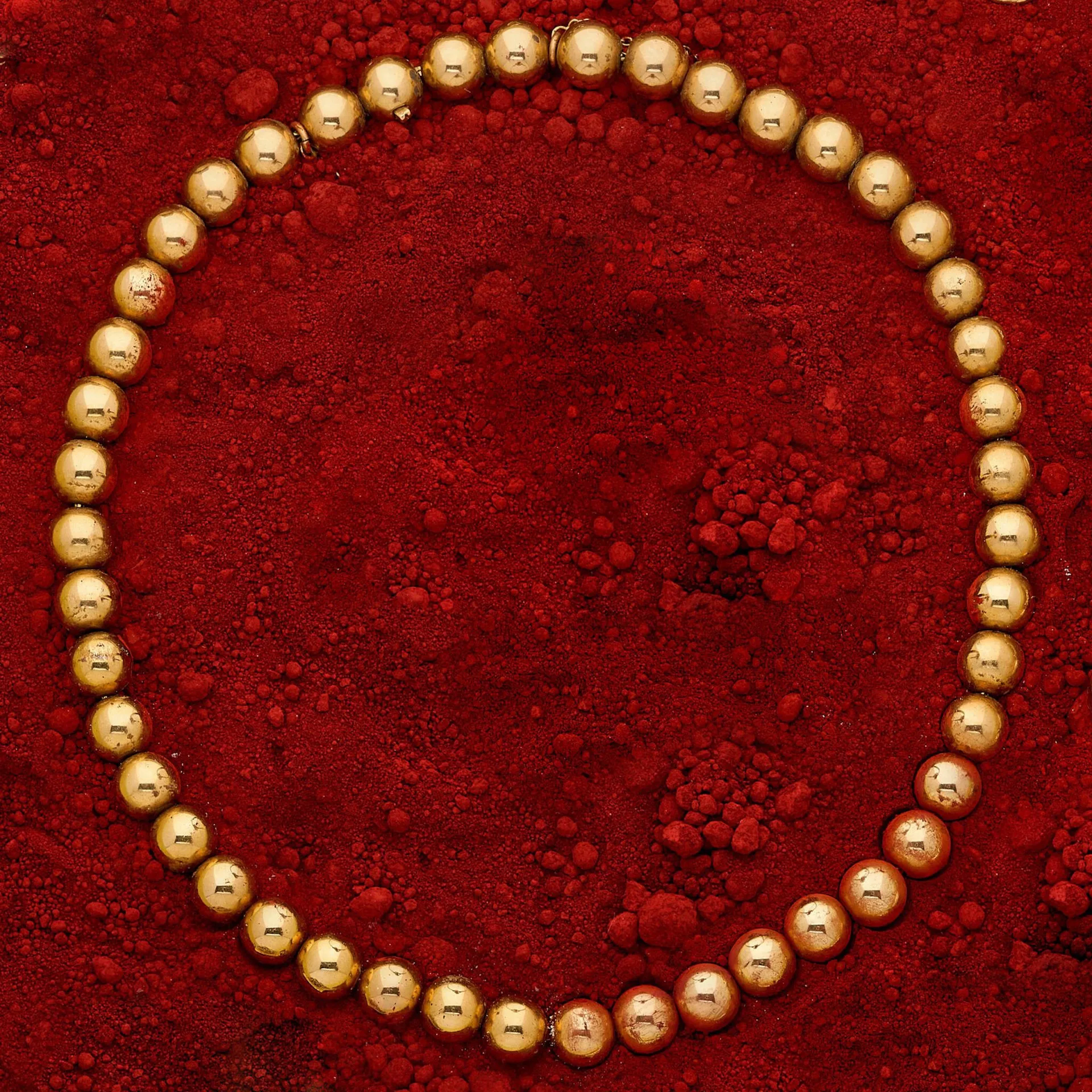 CARTIER Collier en or 18k (750e), composé d'un rang de boules d'or sur une maille palmier, agrémenté d'un fermoir à cliquet invisible avec chaînette de sécurité. (fermoir fatigué) Travail du début du XXème siècle. Signé Cartier Paris, poinçon de maître de Gross. Accompagné de son écrin à la forme signé de la maison. Poids : 48.90 g. Longueur : 39.7 cm.