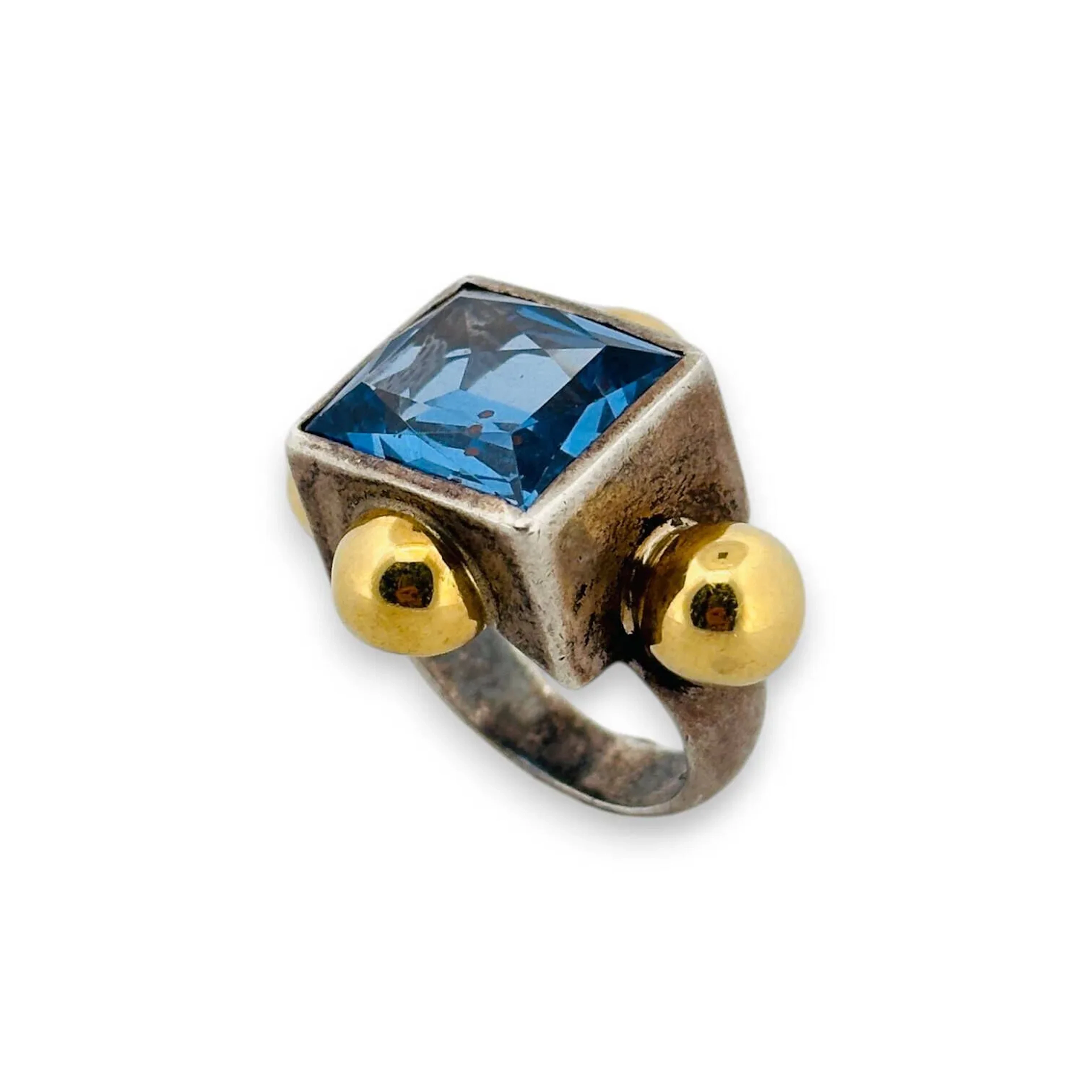 Bague en argent (800) et boules d'or jaune 18k (750) sertie d'un spinelle synthétique bleu rectangulaire à pans vifs. Signée DANIEL SWAROVSKI PARIS. Tour de doigt : 53 - Poids brut : 18.72 g.