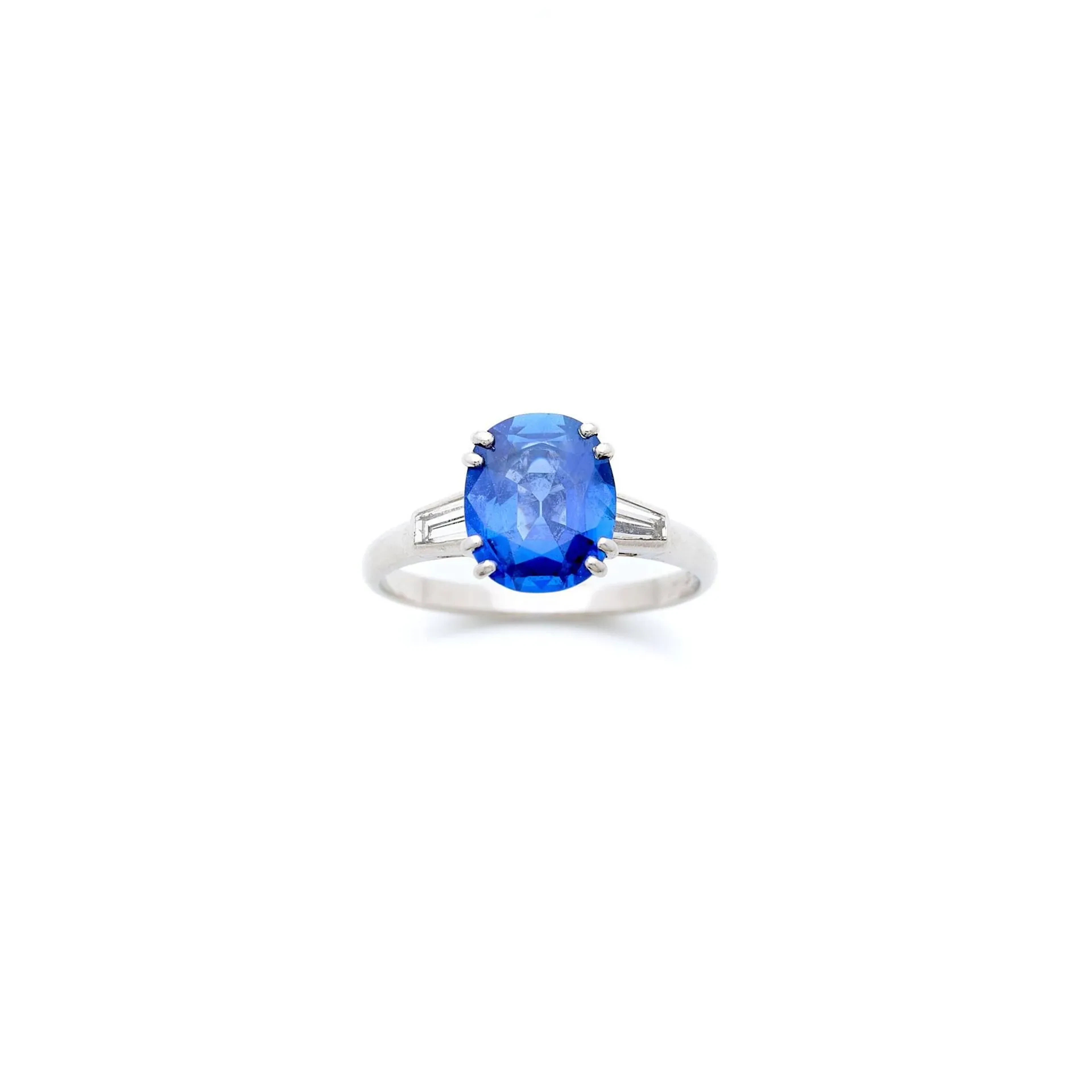 CHAUMET Paris Bague en platine (850e), ornée d’un saphir ovale facetté en serti double griffe, épaulé de 2 diamants tapers. (Très léger manque de matière au saphir) Poids du saphir : 2.50 carats environ. Signée Chaumet Paris. Poids brut : 4.10 g. Tour de doigt : 54. La bague est accompagnée d’un pli gemmologique du Laboratoire GemParis, n°20261978672-2, attestant une origine Sri Lanka, non chauffé.