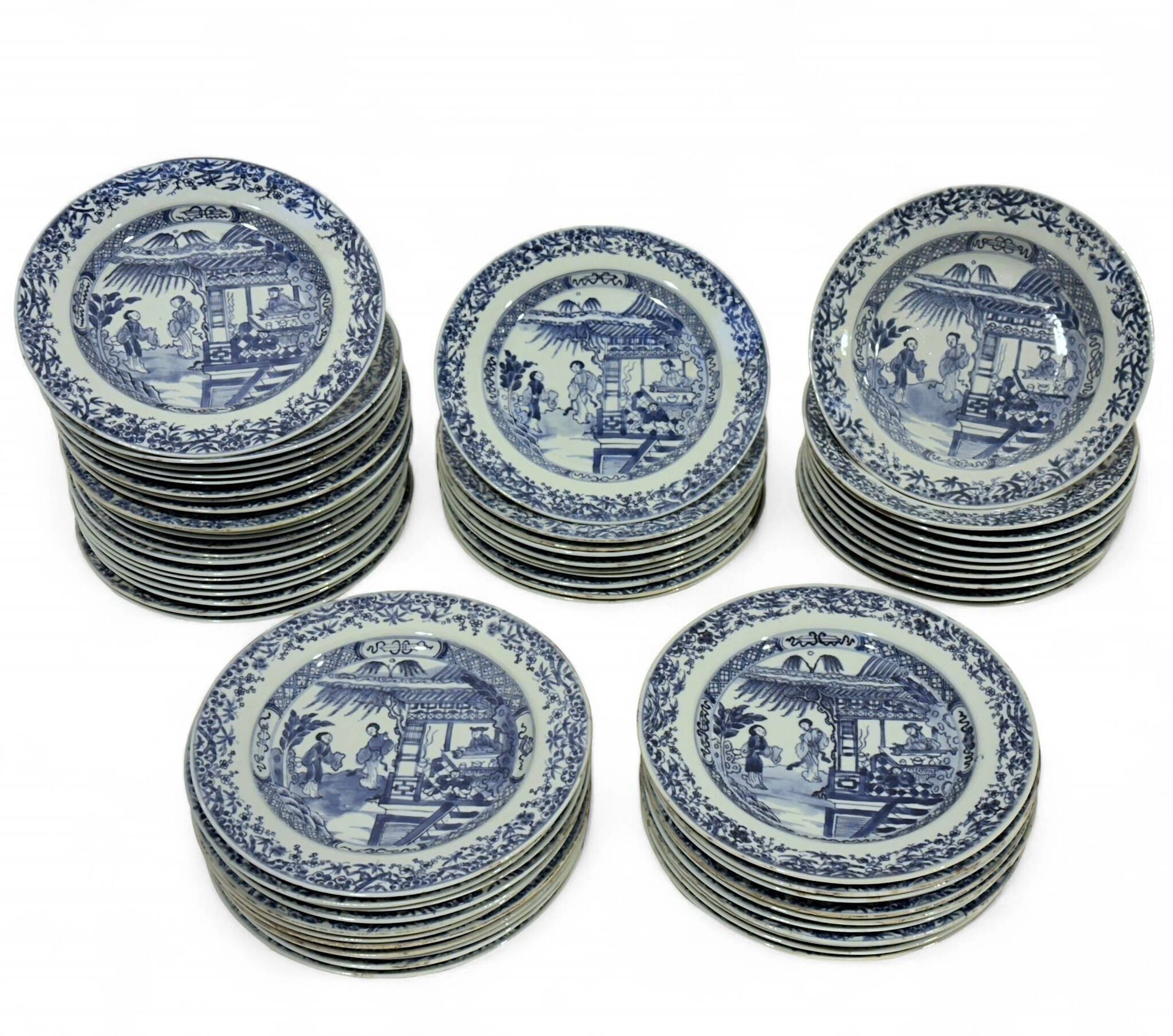 CHINE - XVIIIe siècle Service en porcelaine bleu blanc à décor émaillé en bleu sous couverte d'un épisode du Xixiang Ji (La Romance du pavillon de l'Ouest): deux femmes de cour dans des jardins autour d'un pavillon dans lequel un homme joue du qin pendant qu'un serviteur est assoupi devant lui. L'aile ornée de frises de feuilles et bambous. Il est composé de dix assiettes creuses et cinquante-trois assiettes plates. (égrenures, éclat et fêlures) Diam. 23 cm