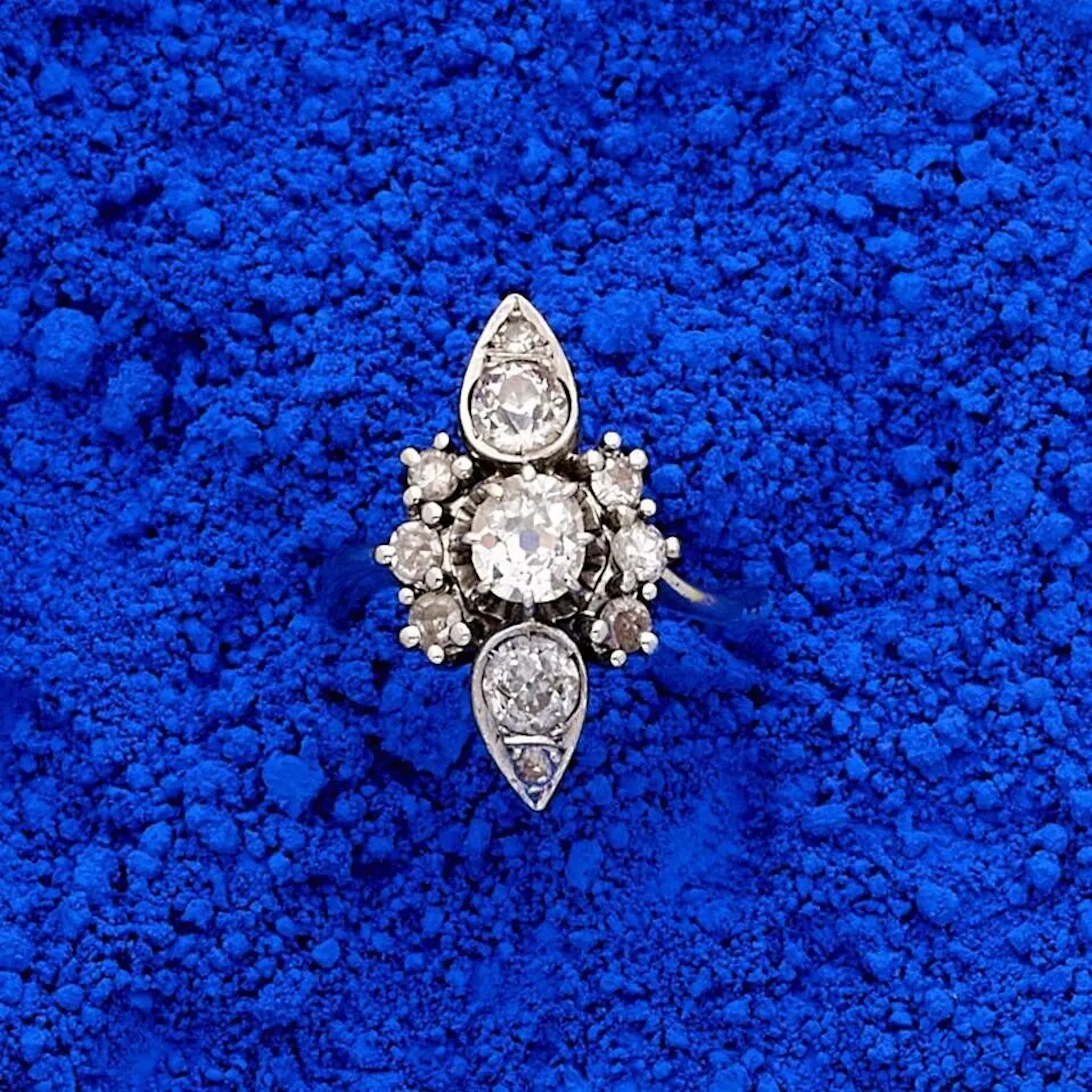 Bague marquise en or gris 18k (750e), centrée d'un diamant taille coussin pesant environ 0.50 ct, encadré de 2 motifs en forme de poire rehaussés de diamants taille ancienne et 8/8. Poids brut : 5.50 g. Tour de doigt : 51.