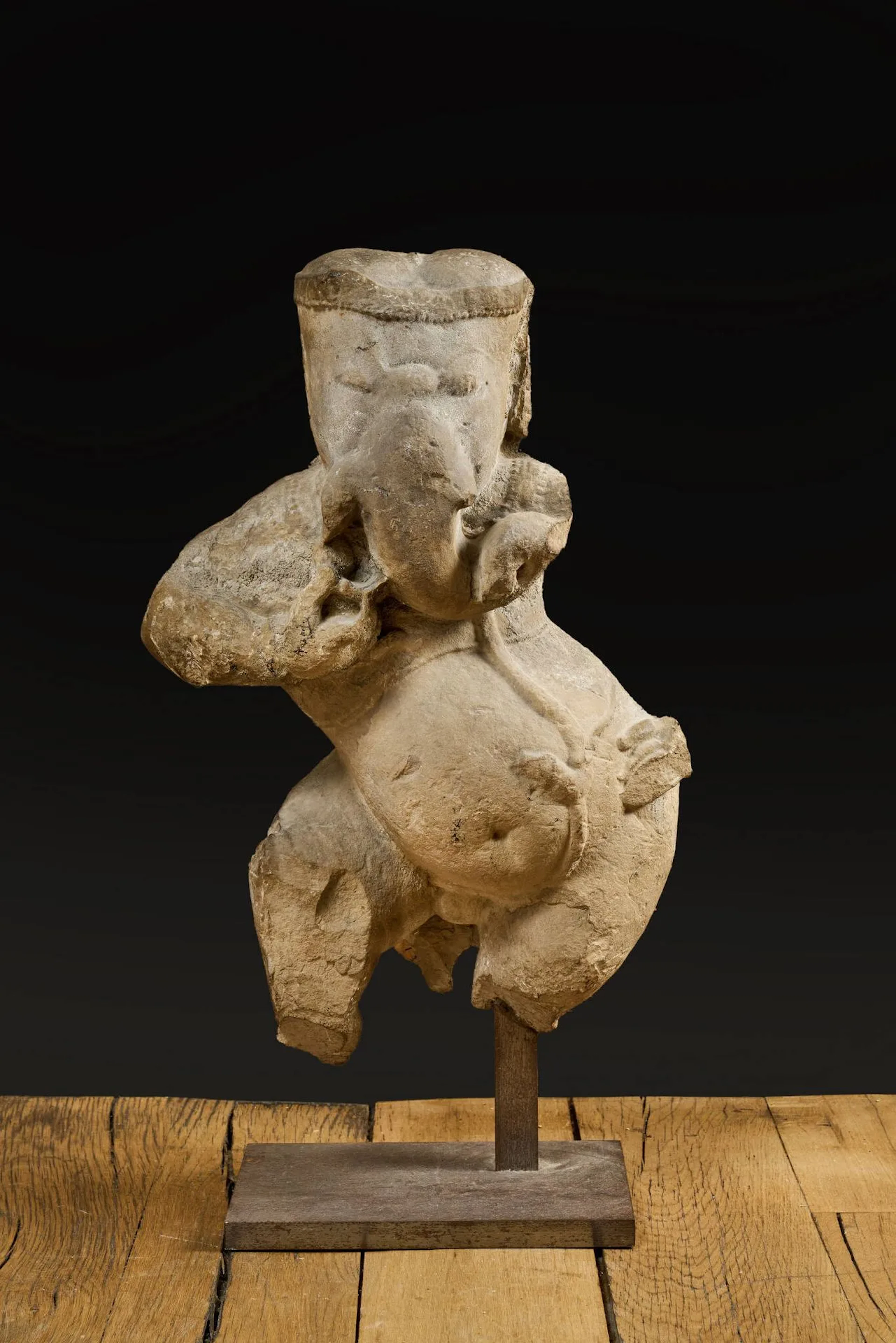 INDE - Période médiévale, Xe/XIIIe siècle Statue en grès gris, Ganesh debout en tribhanga, dansant, la main droite repliée vers sa trompe, la gauche touchant son ventre. (Fragmentaire) H. 53,5 cm Socle