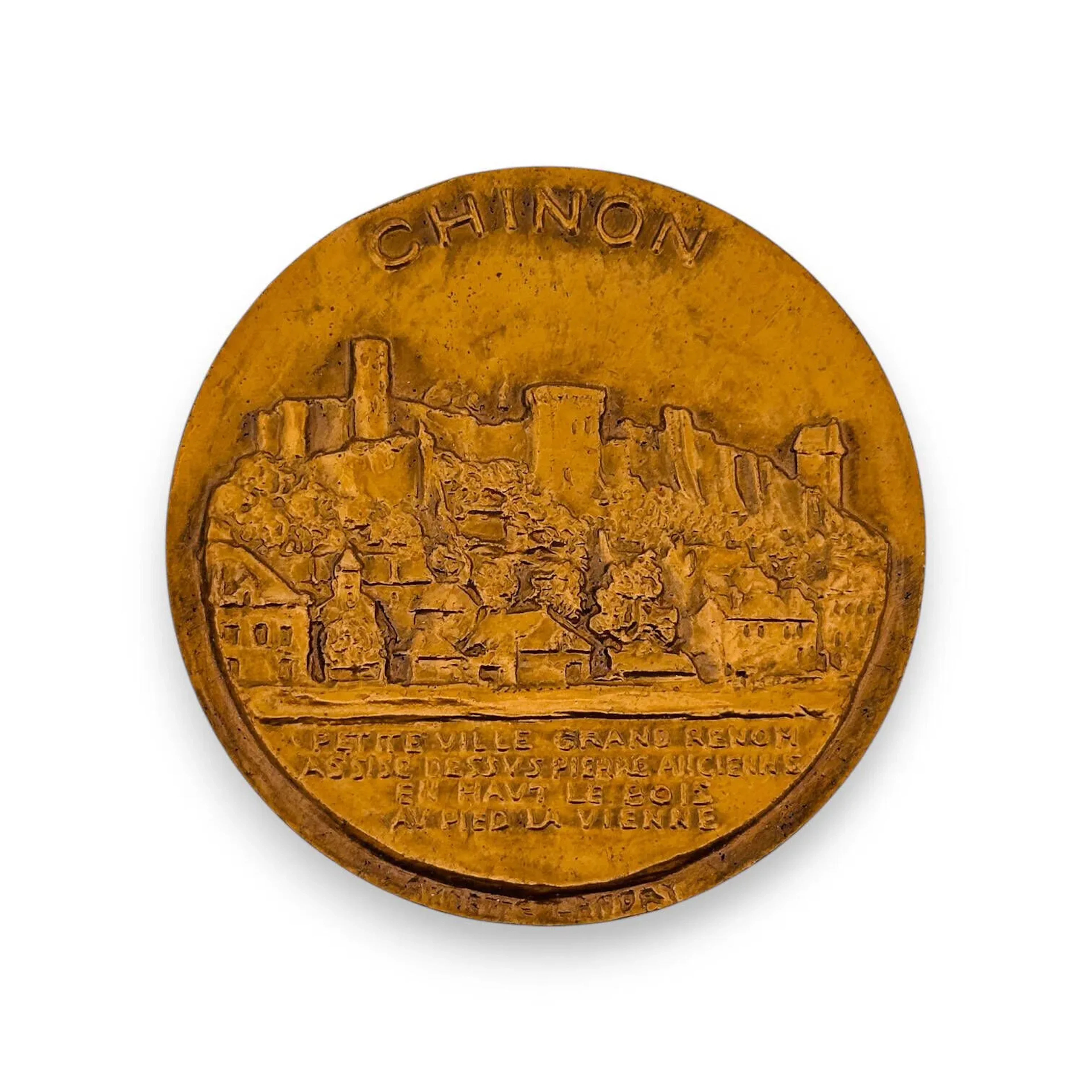 Médaille en bronze (corne d'abondance). Avers : Devise de la ville : PETITE VILLE GRAND RENOM ASSISE DESSUS PIERRE ANCIENNE EN HAUT LE BOIS AU PIED LA VIENNE. Vu générale du château prise de la route de Candes. Revers : Un pied de vigne. A gauche une allusion à la première rencontre de Jeanne d'Arc avec Charles VII. A droite Gargantua et ses compagnons. Signée Annette Landry. TTB à SUP Diamètre : 59 mm.