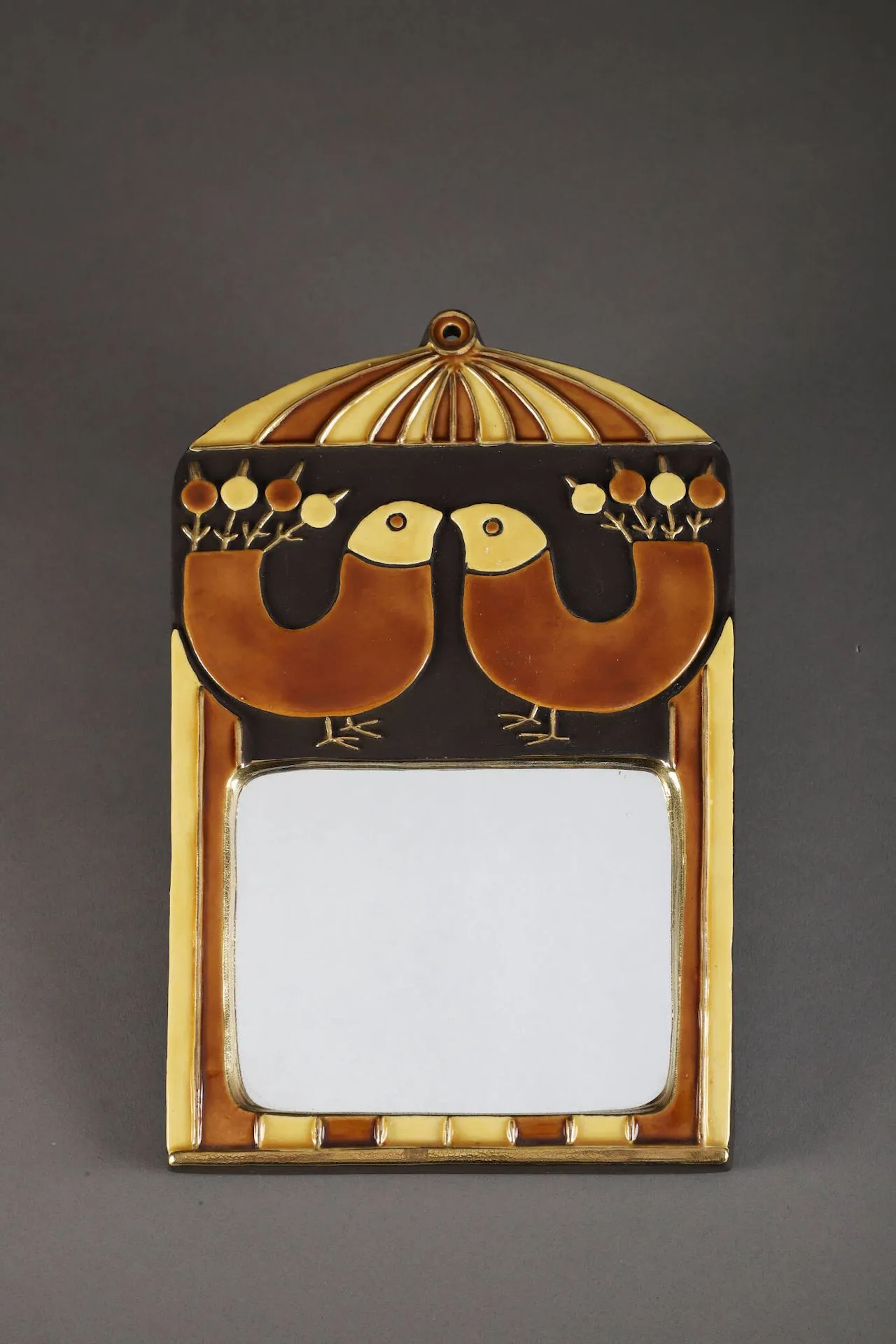Mithé ESPELT (1923-2020) Miroir mural de forme rectangulaire Épreuve en terre estampée et émaillée brun, ocre et or craquelé à décor d’oiseaux et de fleurs. H. : 31 cm. – L. : 19.5 cm.