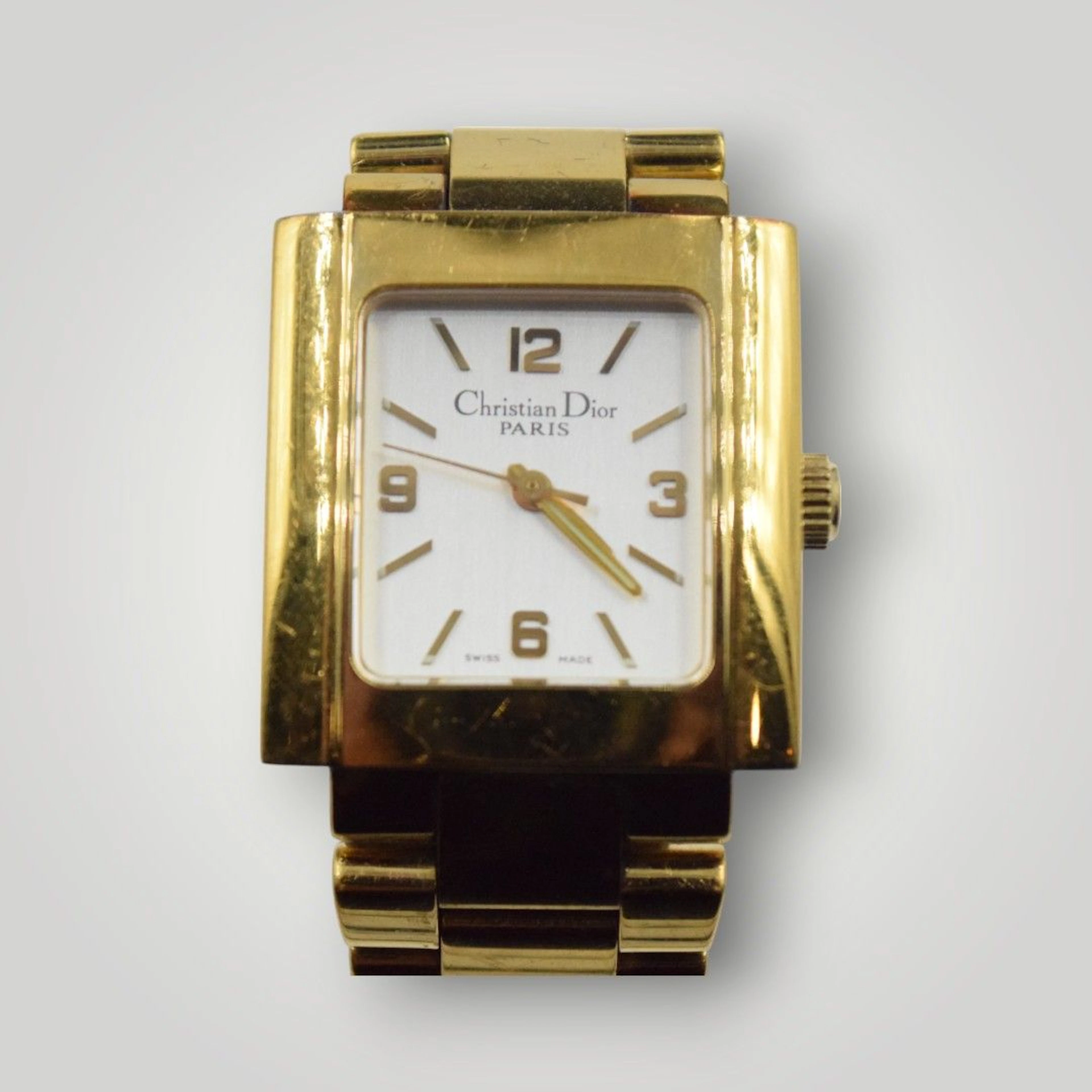 CHRISTIAN DIOR Montre d'homme en métal doré à cadran rectangulaire émaillé blanc, bracelet souple, rayures d'usage 7.5 cm de diamètre