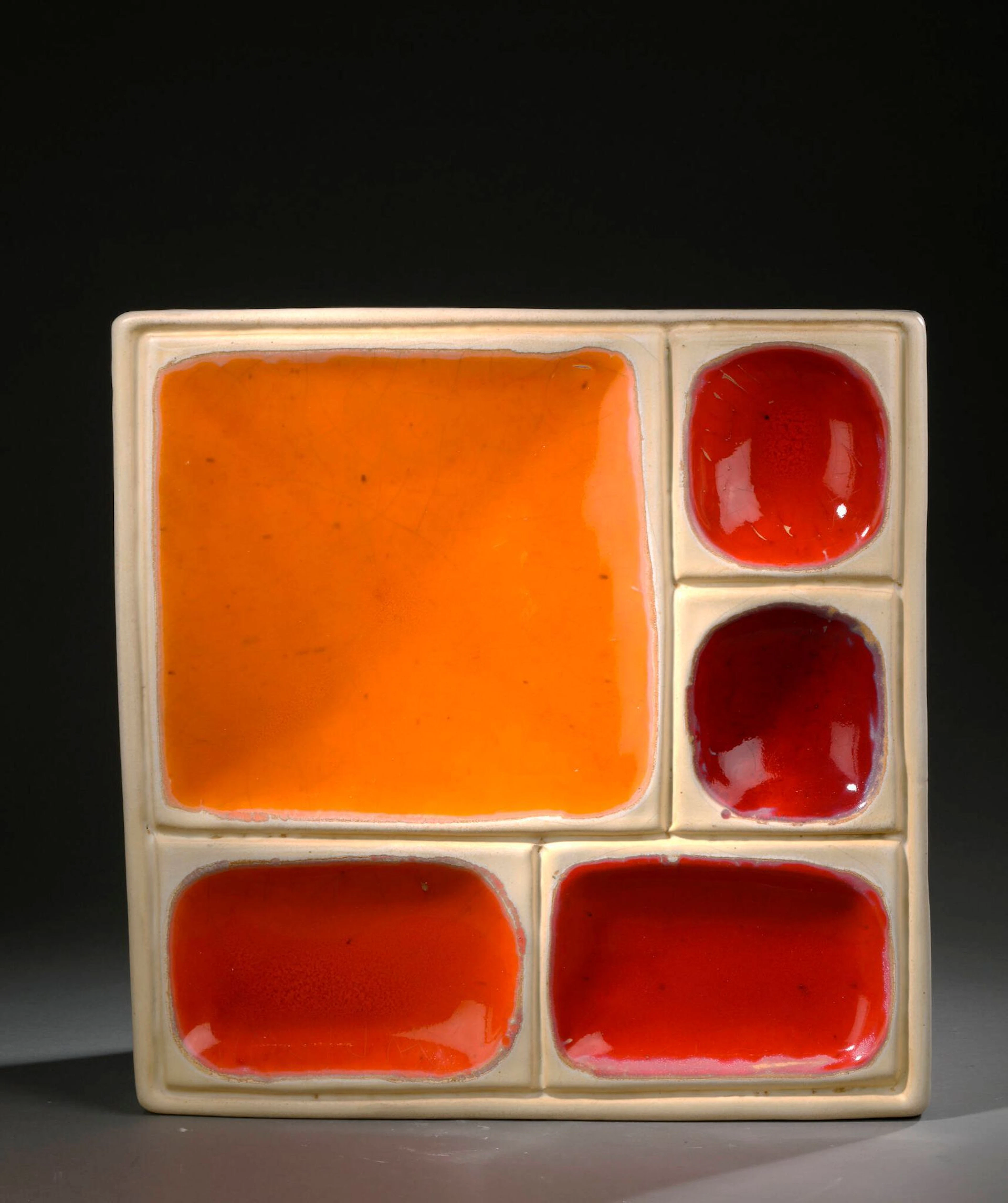 Georges JOUVE (1910-1964) Bas-relief, circa 1954 de forme carrée à décor géométrique en creux Épreuve en céramique émaillée blanc, rouge et orange Signé Jouve et porte le sigle alpha de l’artiste. H. : 44 cm. L. : 43 P. : 4 cm. (Usures, défauts d’émaillage et légères altérations) Bibliographie : - Georges Jouve, Edition Jousse entreprise, 2005, modèle à rapprocher reproduit p. 249.