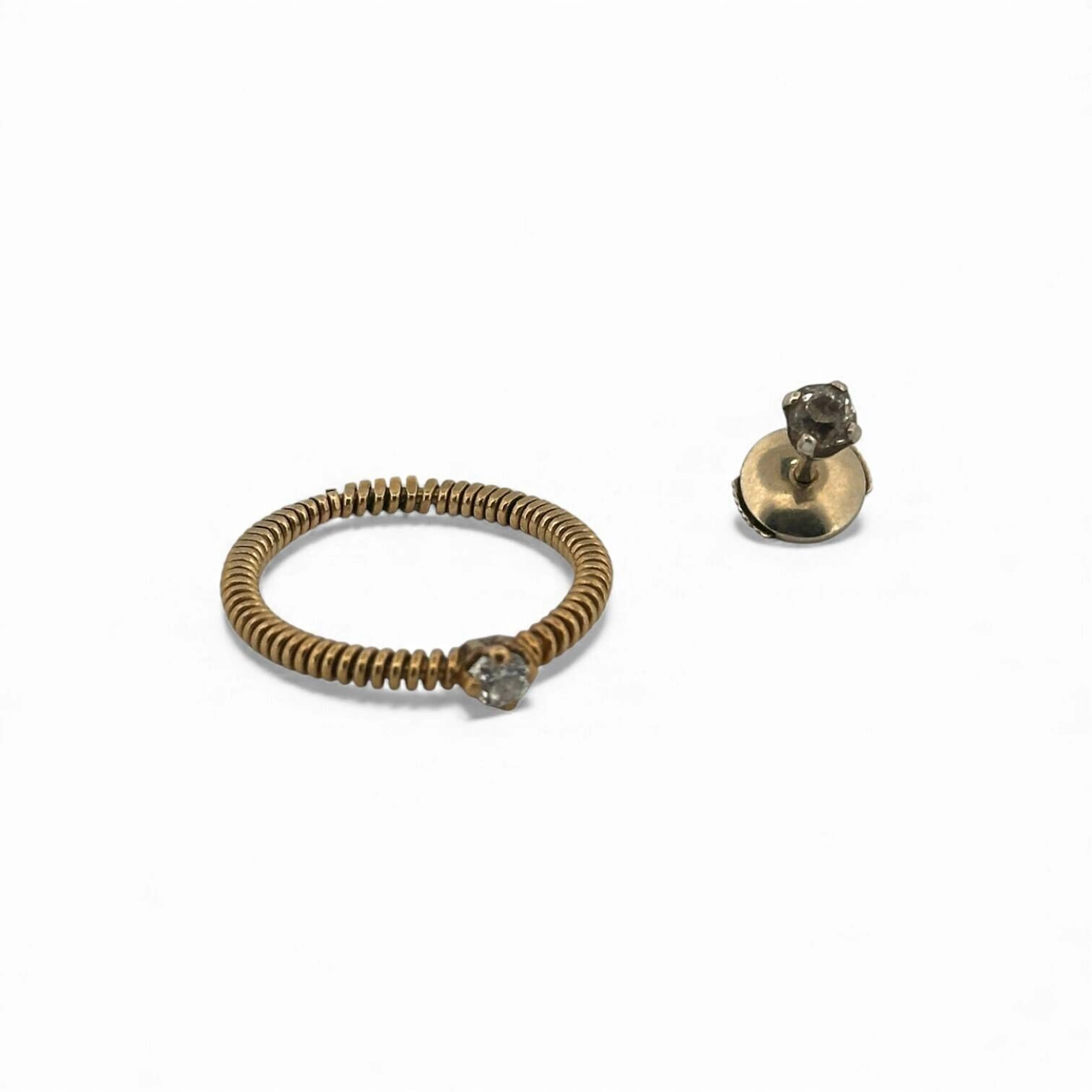 Suite de bijoux en or 18K (750) comprenant une alliance sertie d'une pierre blanche et un clou d'oreille orphelin serti d'un diamant taillé en rose. Poids brut total : 3.03 g.