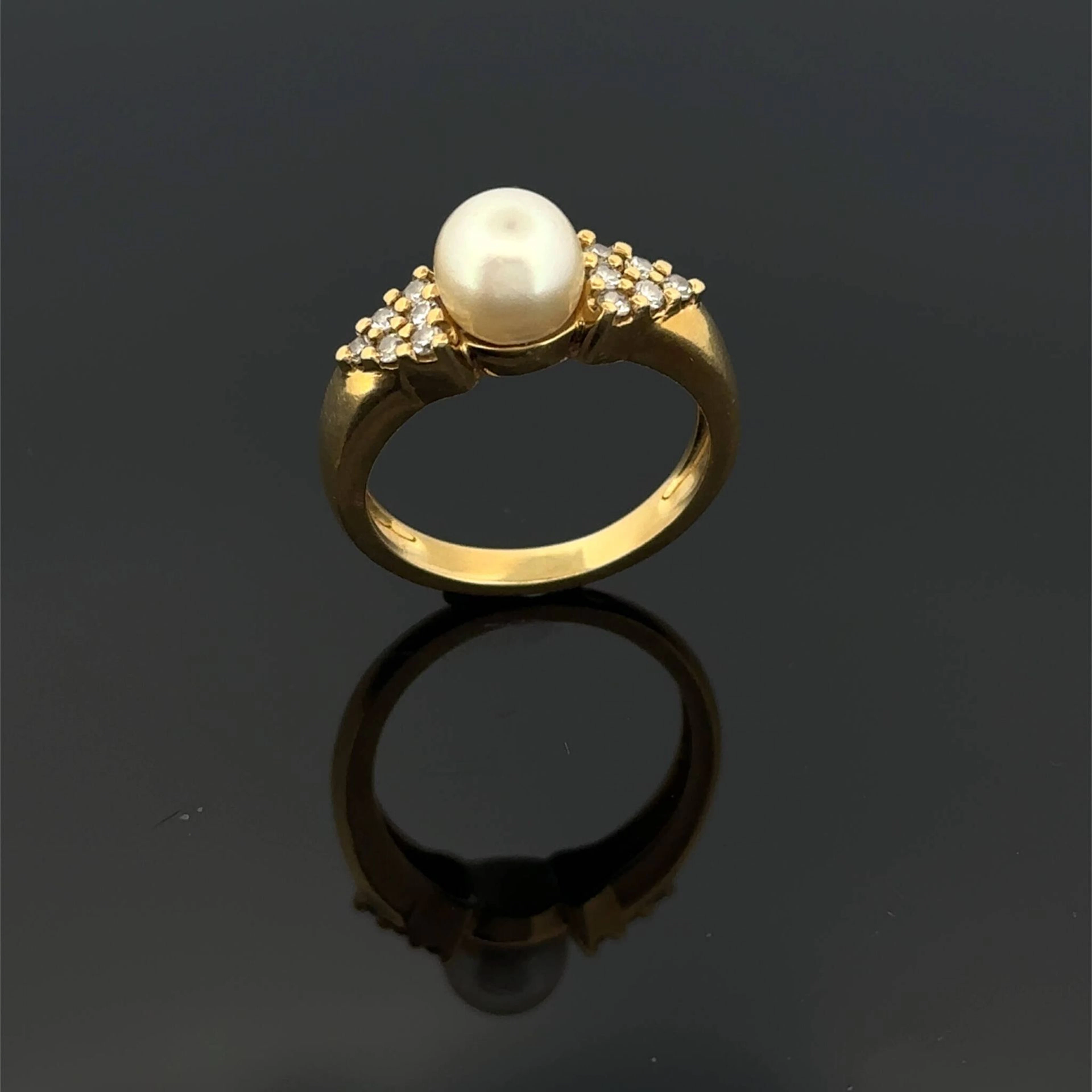 Yellow gold (750) ring set with a cultured pearl flanked by - Lot 209