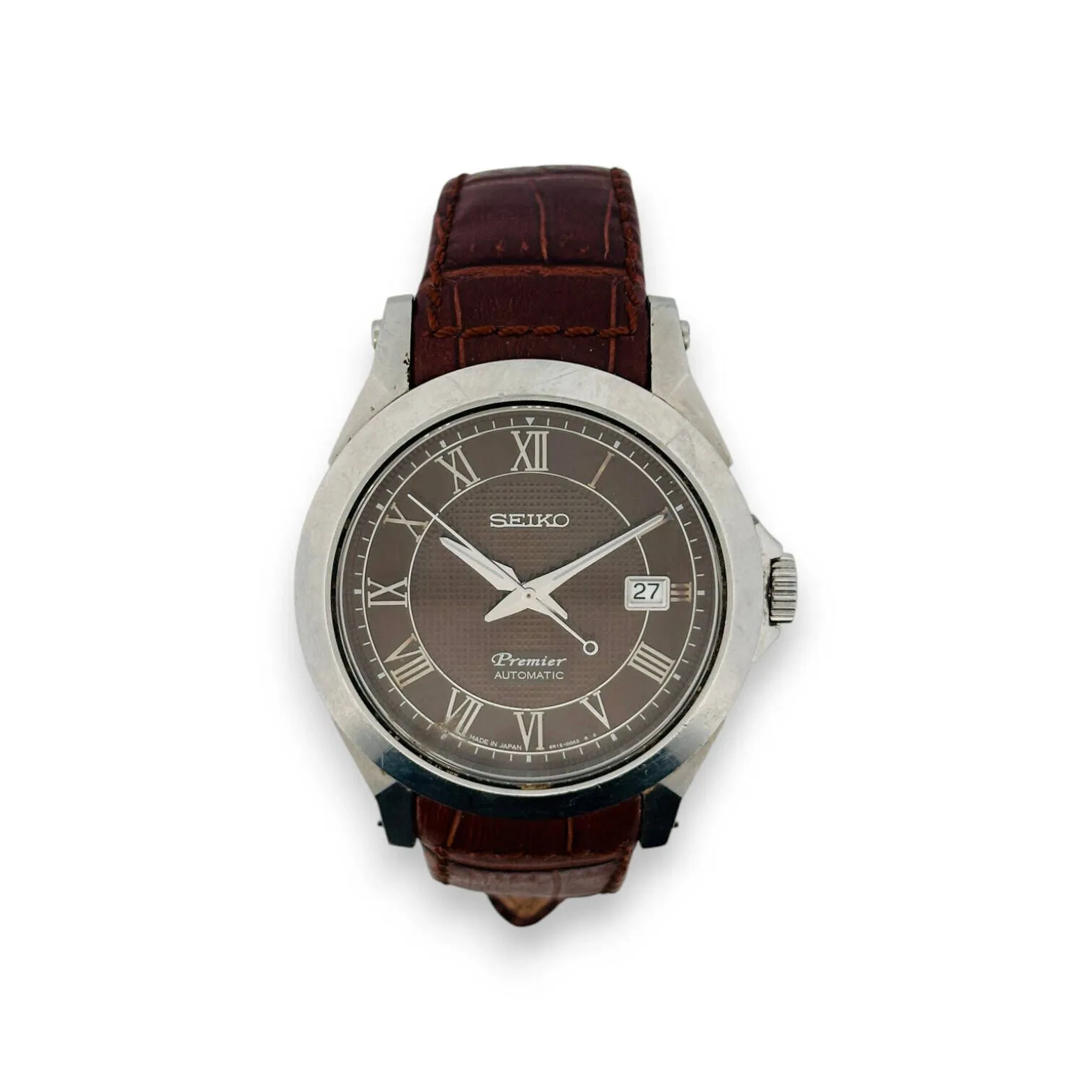 SEIKO Premier Montre bracelet pour homme, boitier en acier, cadran marron, mouvement automatique, index chiffres romains formant les heures, date par guichet à 3h, mouvement automatique, bracelet intégré en cuir marron à boucle ardillon signée. Conservée dans une boite de la marque. Diam. : 42 mm (rayures d'usage)