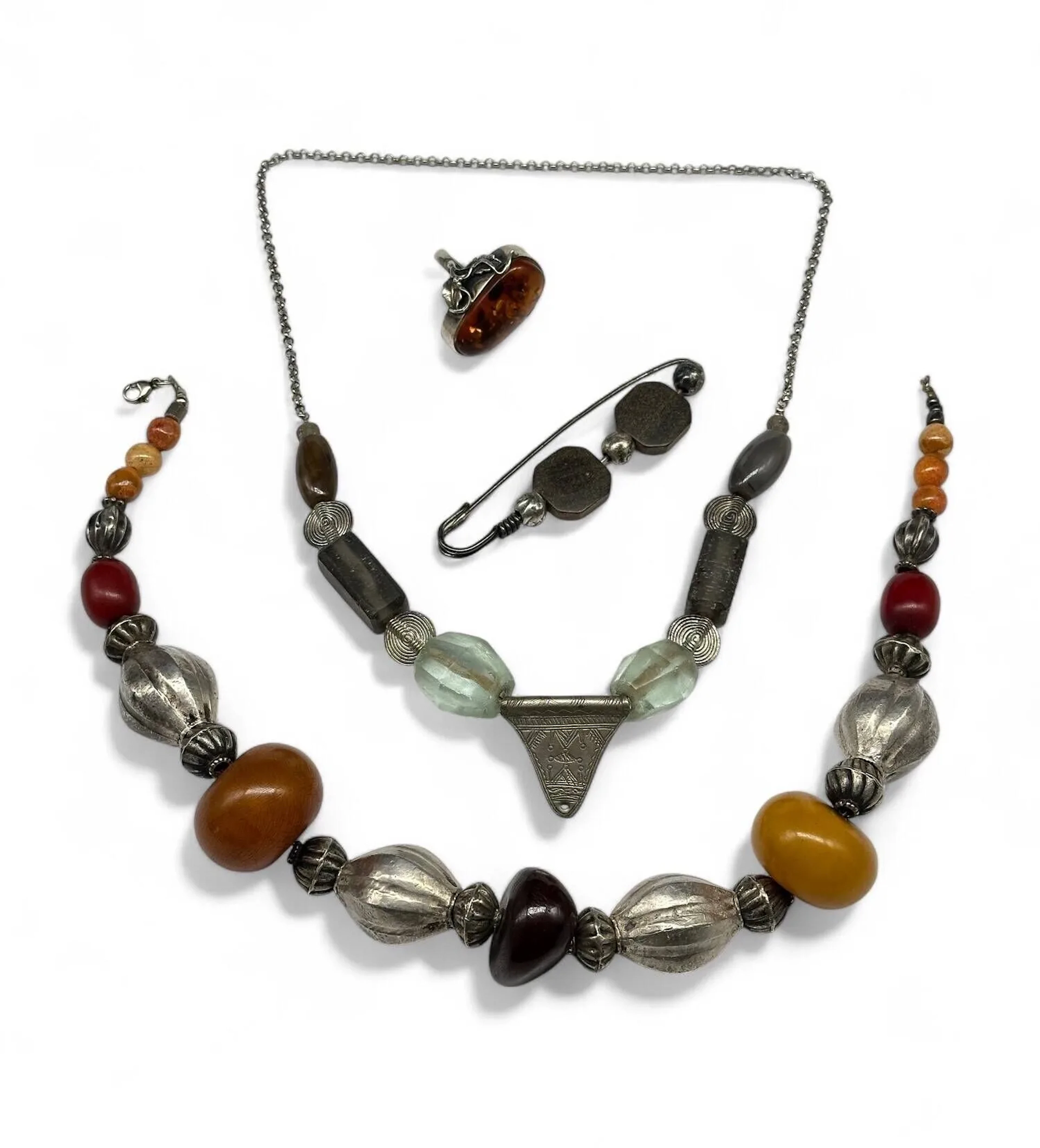 Collier et une bague en argent (800) à la monture décorée de feuillage ornée d'une ambre et pierres de couleurs Poids brut total : 168,7 grammes On y joint une broche (L : 9 cm) et un collier (L : 47 et 52 cm env.)