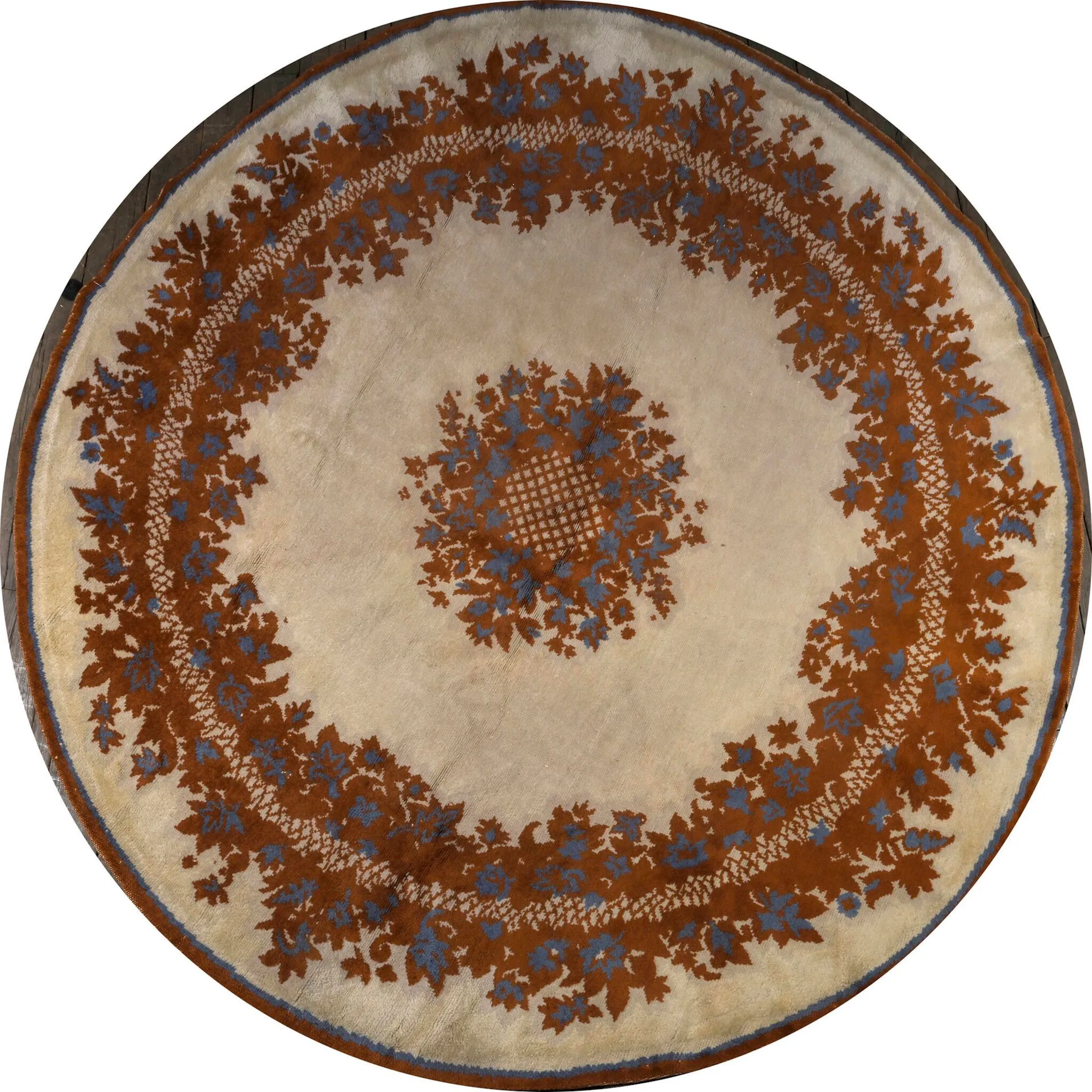 Paule LELEU (attribué à) Tapis circulaire en laines de couleurs à décor de deux couronnes de fleurs stylisées et d’un liseré rouge et bleu sur fond beige. Etiquette portant une numérotation au revers. Diam. 195 cm