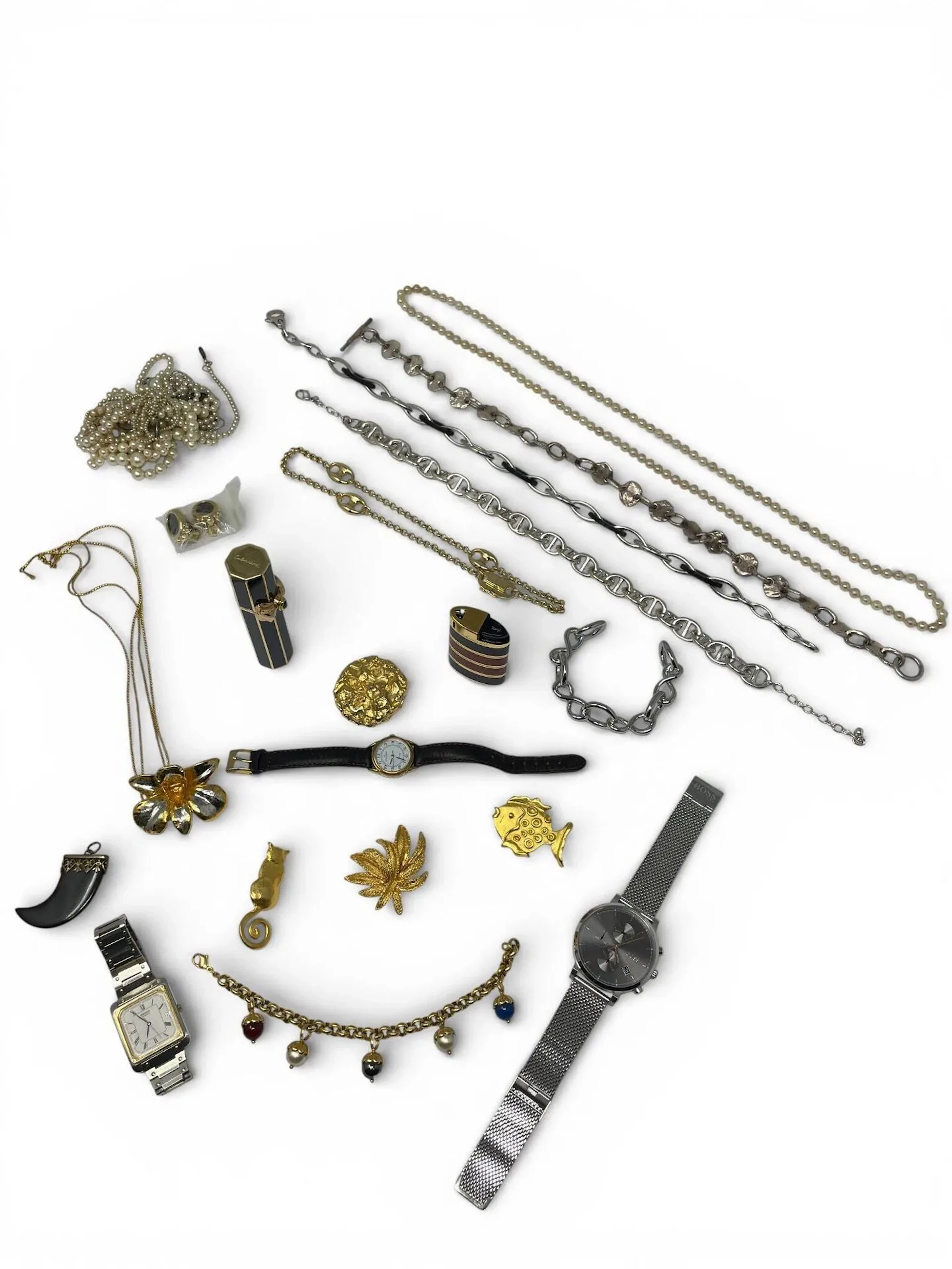 Important lot de bijoux fantaisies. Certains griffés. On y joint une montre BOSS et un briquet YVES SAINT LAURENT. Vendus en l'état.