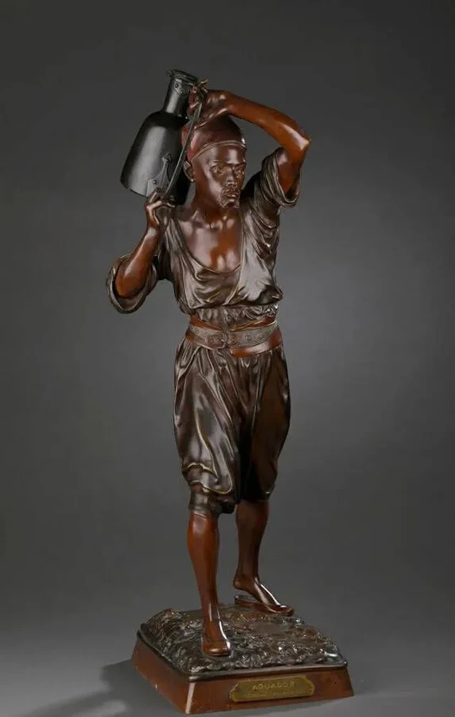 HIOLIN Louis Auguste, 1846-1910 Aguador Bronze à patines brun-roux et brune nuancée (traces d’usures à la patine) Sur la terrasse : Hiolin et un cachet BRONZE GARANTI AU TITRE PARIS, sur l’avant un cartouche avec le titre et la mention MÉDAILLE BEAUX ARTS Ht. : 69 cm