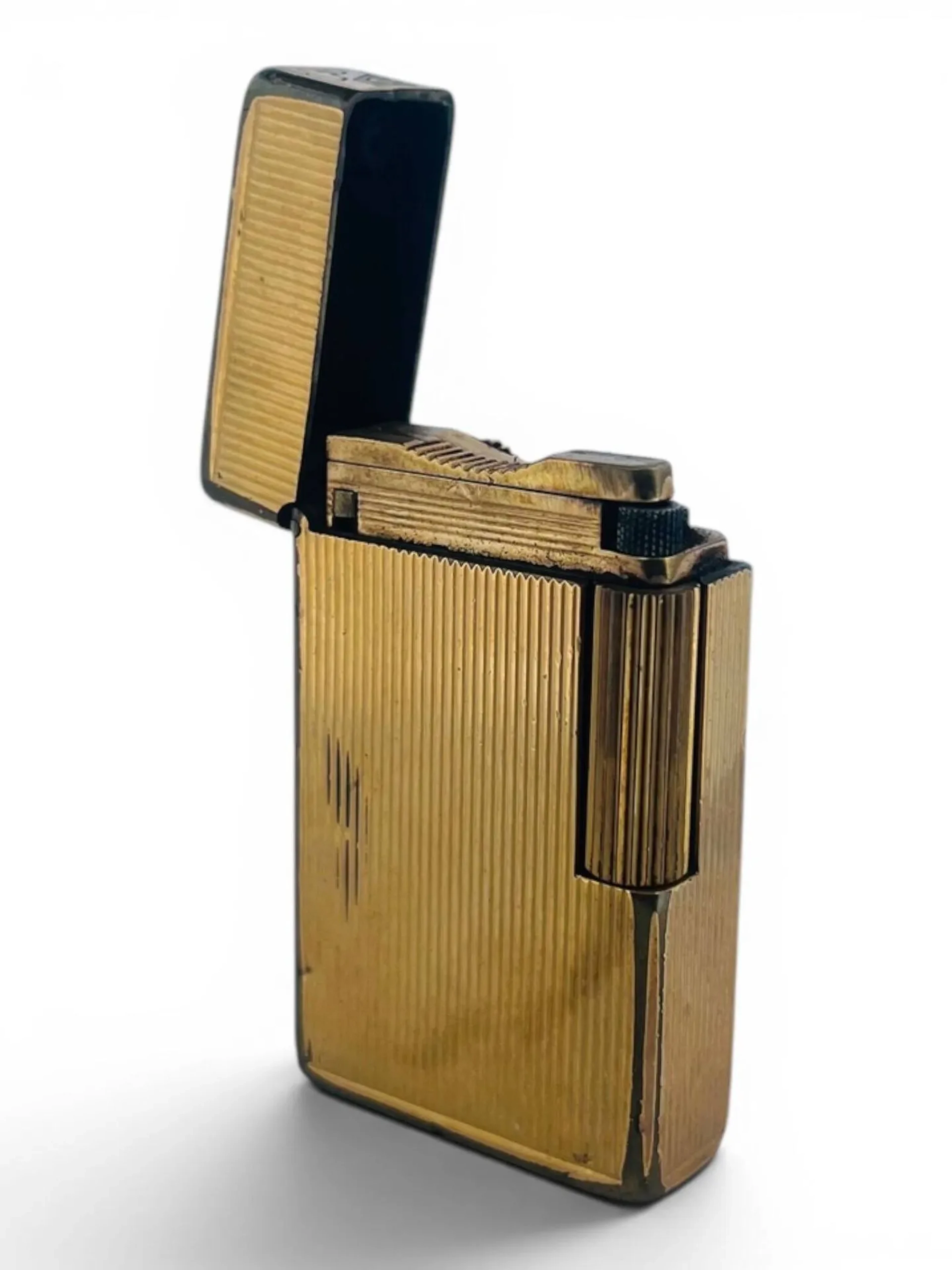 S.T. DUPONT Briquet standard grand modèle en plaqué or à décor cannelé. Signé sur le dessous et numéroté 0887C7. Dim. 58 x 35 mm Usures au plaquage
