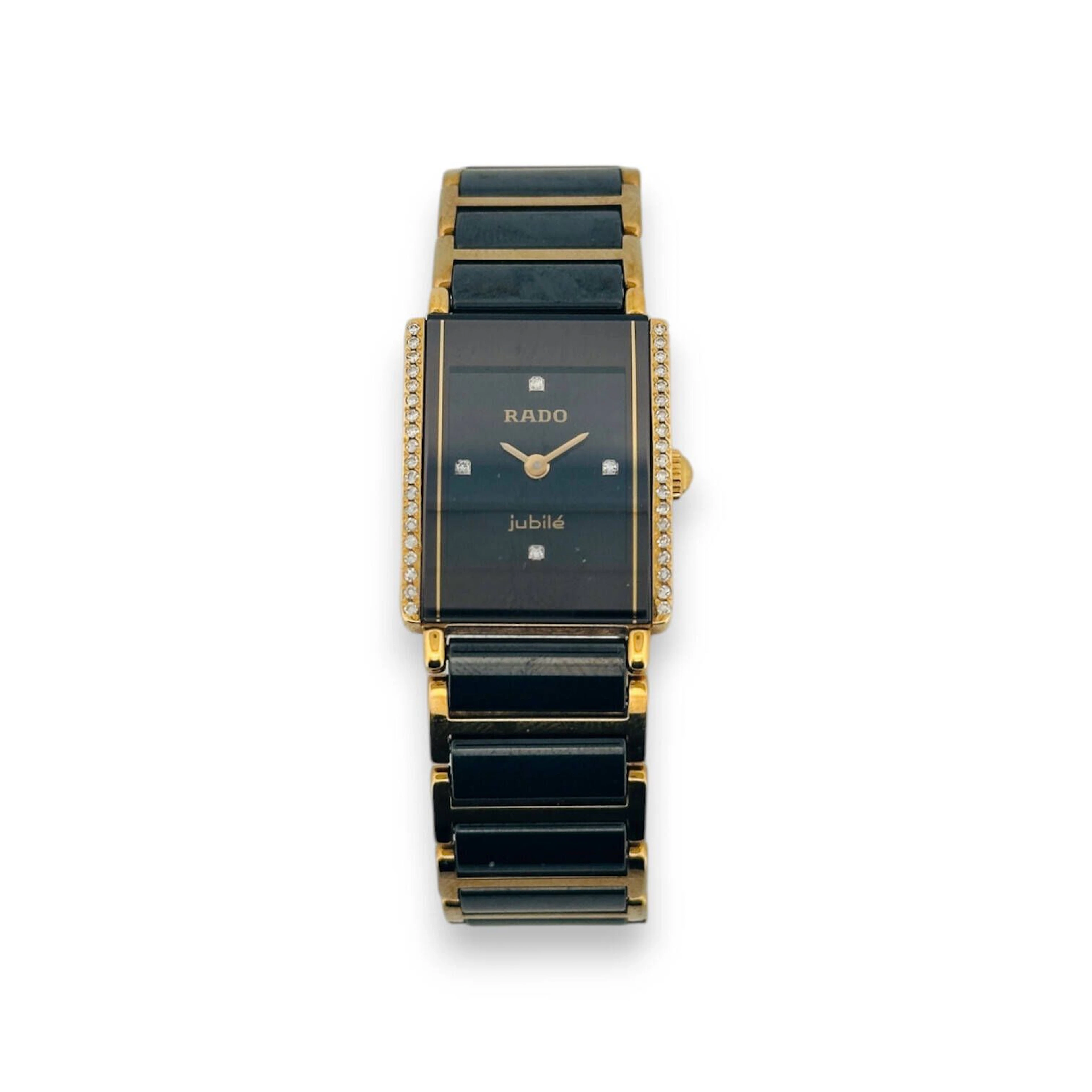 RADO Montre bracelet de dame modèle "Jubilé" en céramique noire et métal doré à boîtier rectangulaire agrémenté de 2 lignes de brillants, cadran noir à index diamants appliqués, fond clipsé sécurisé par 4 vis, signé et numéroté 153.0339.3, n° 04522917. Bracelet à boucle déployante Mouvement à quartz Petites usures