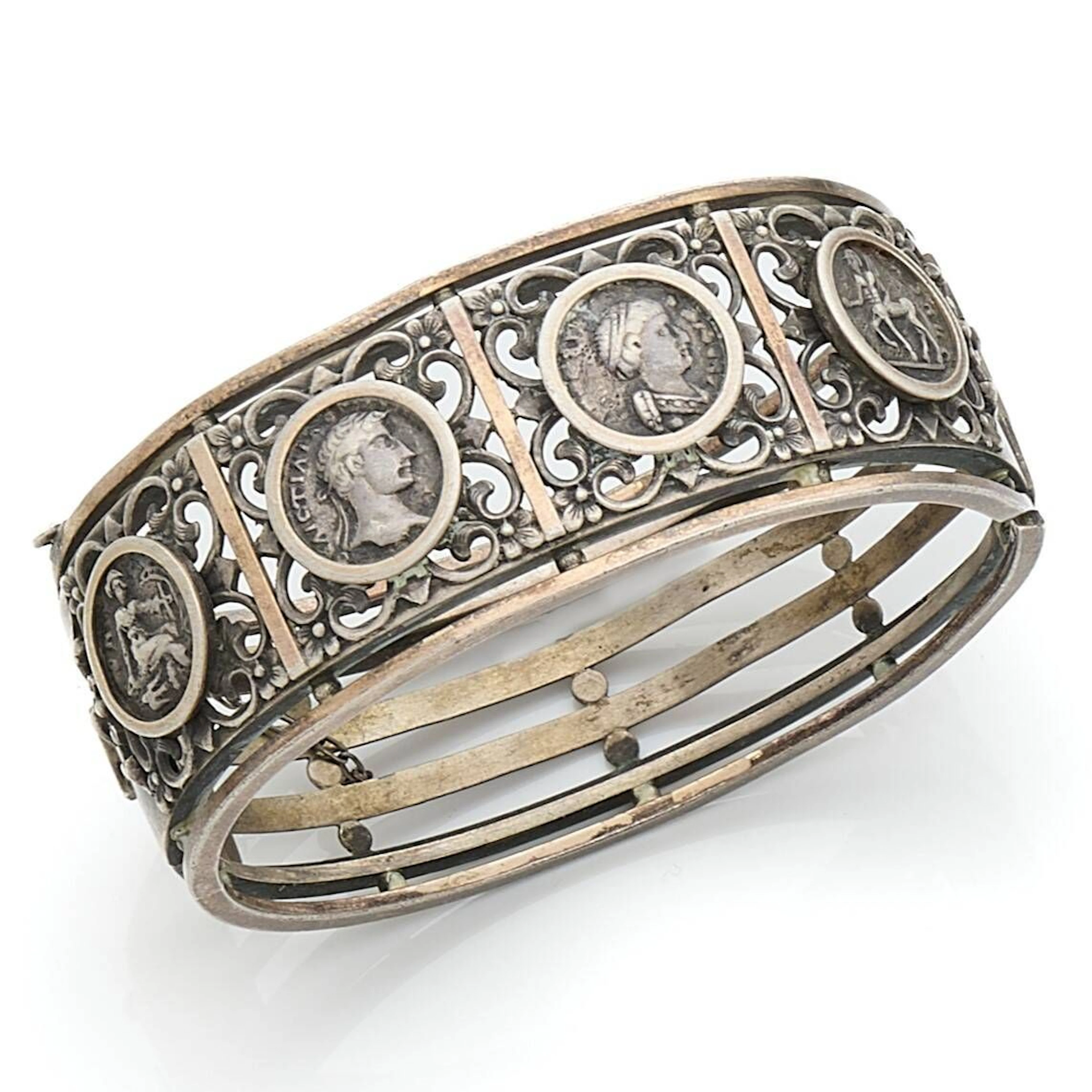 Bracelet ouvrant en argent orné de monnaies antiques ou imitations dans des montures repercées de peltes feuillagées. Travail français de la seconde moitié du XIXe siècle. Dimensions : 19 x 2,5 cm environ. Poids : 44,6 g (déformations)