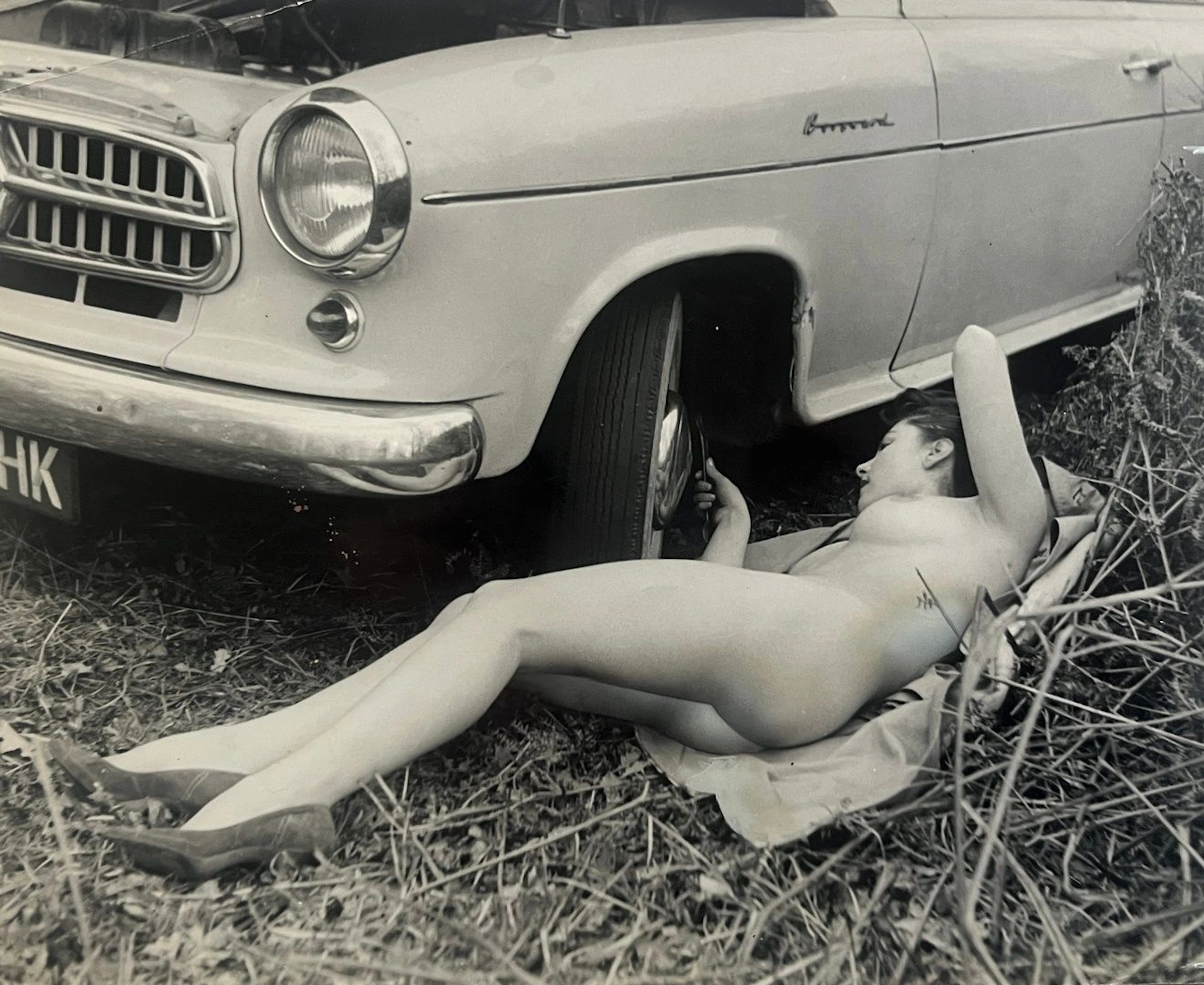 Nu féminin Femme mécanicienne, photographie érotique, 7 février 1968 Tirage argentique de presse, rehaut de gouache sur l’image, daté et marques de cadrages au dos 19.5 x 24 cm - pliure au coin gauche