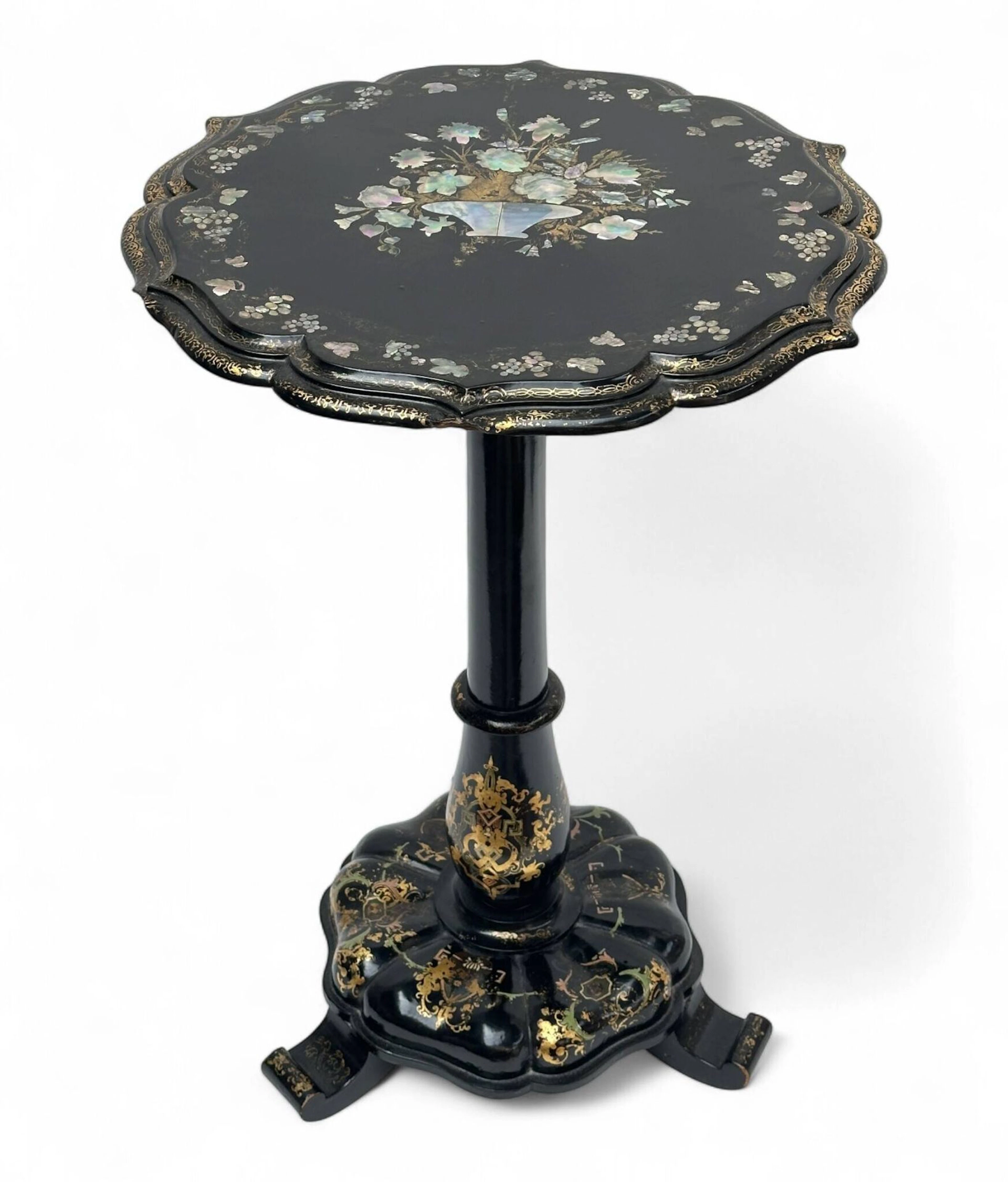 Guéridon circulaire en bois et carton bouilli, laqué noir, à fin décor burgauté, polychrome et or. La base et le plateau circulaire chantournée, réuni par un fût en colonne. Le plateau abattable est centré d’un panier fleuri et orné d’une frise de pampres. Époque Napoléon III H : 73 cm, diam : 51 cm (usures, petits manques)