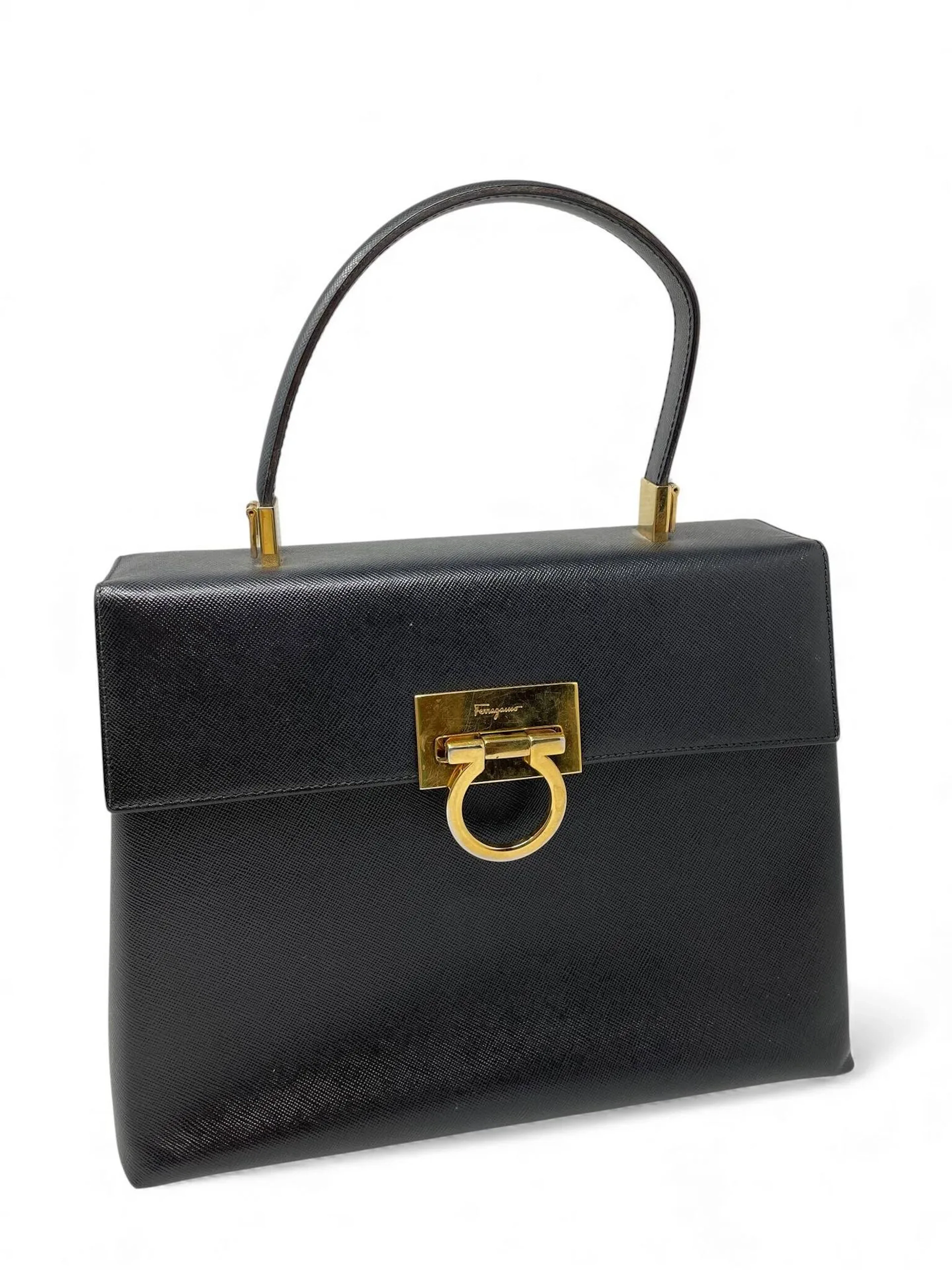 SALVATORE FERRAGAMO Sac porté main ou épaule en cuir grainé noir Bijouterie en métal doré Doublure en nylon noir Bandoulière amovible Bon état, très légères traces et frottements Dimensions : 26x20x10 cm environ