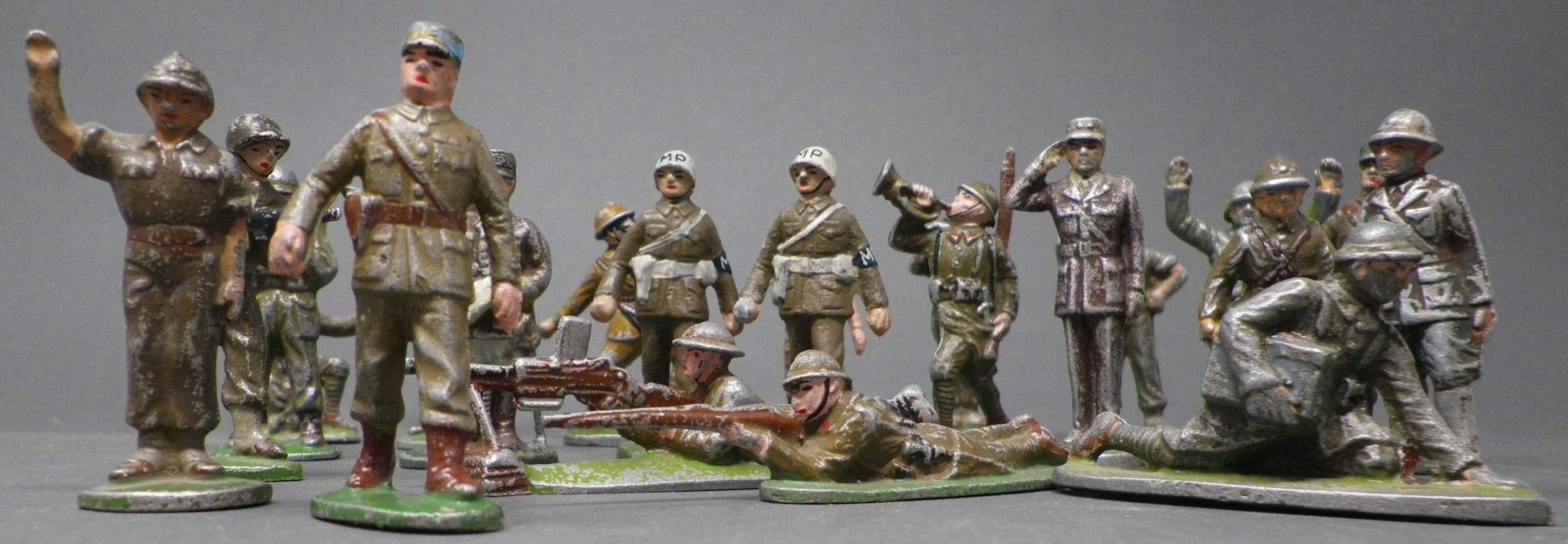 QUIRALU & DIVERS - DIVERS MAJORITAIREMENT MILITAIRES Dont : - soldats anglais en tireurs couchés, p. 125 - membres de la Military Police à pied - Général de Gaulle 1944, socle rond saluant militairement, p.154 - Général Gamelin, p.154 - clairon sonnant la charge, p. 46 Plus de 40 pièces. Bibliographie : Les jouets Quiralu 1933-1964 - R. Alazet - J. Borsarello - H. Giroud - Ed° J. Granchet Paris. Jouets anciens pouvant présenter des manques de peinture, des chocs ou des manques, y compris pour les conditionnements éventuels. Vendus en l'état et sans réclamations.