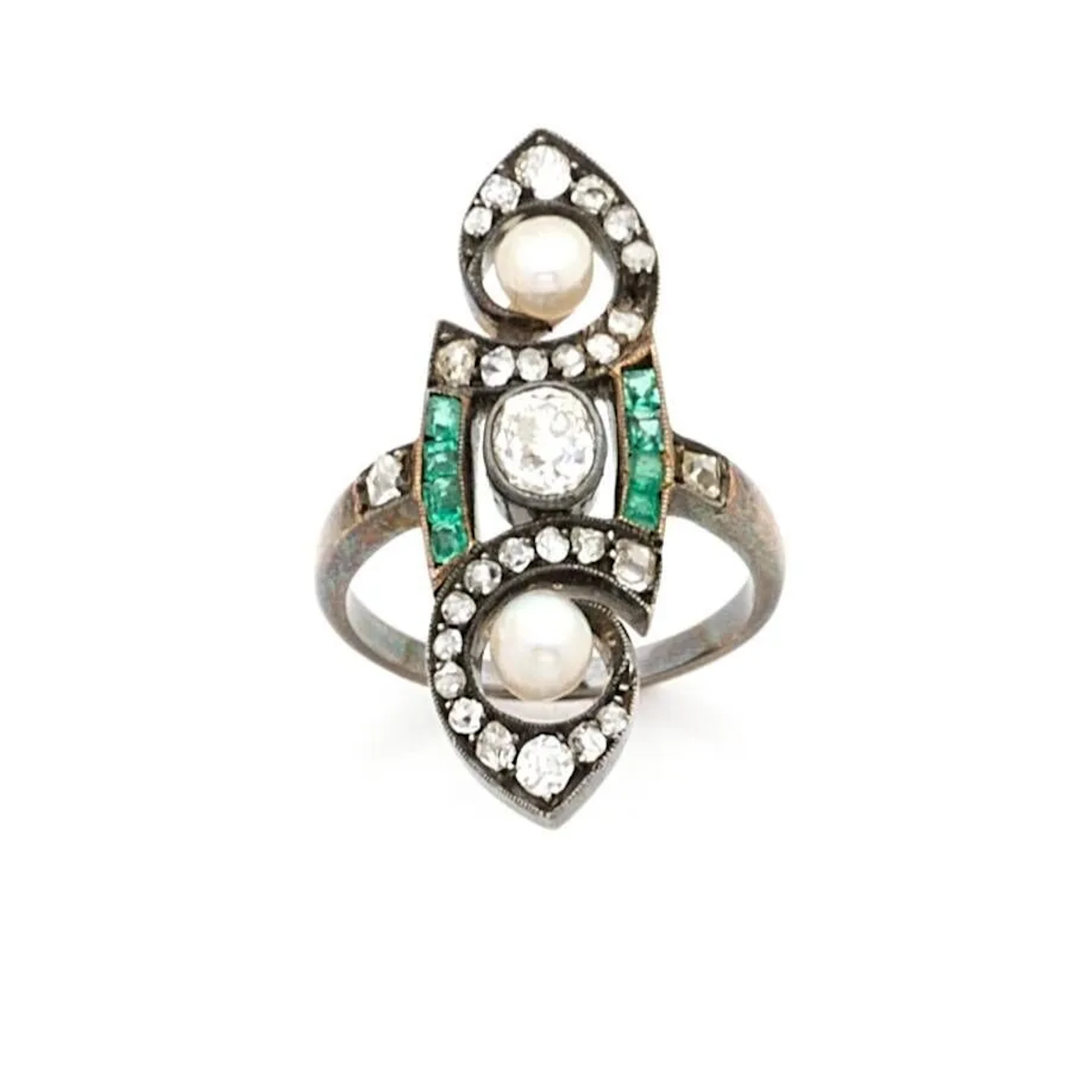 Bague marquise en or 18k (750e) et argent (800), ornée d'un diamant taille ancienne pesant 0.30 carat, encadrée de 2 perles boutons, dans un entourage d'enroulements rehaussés de diamants taillés en rose et de calibrés d'émeraudes. (manque une pierre) Vers 1900. Poids brut: 6.80 g. Tour de doigt: 56.
