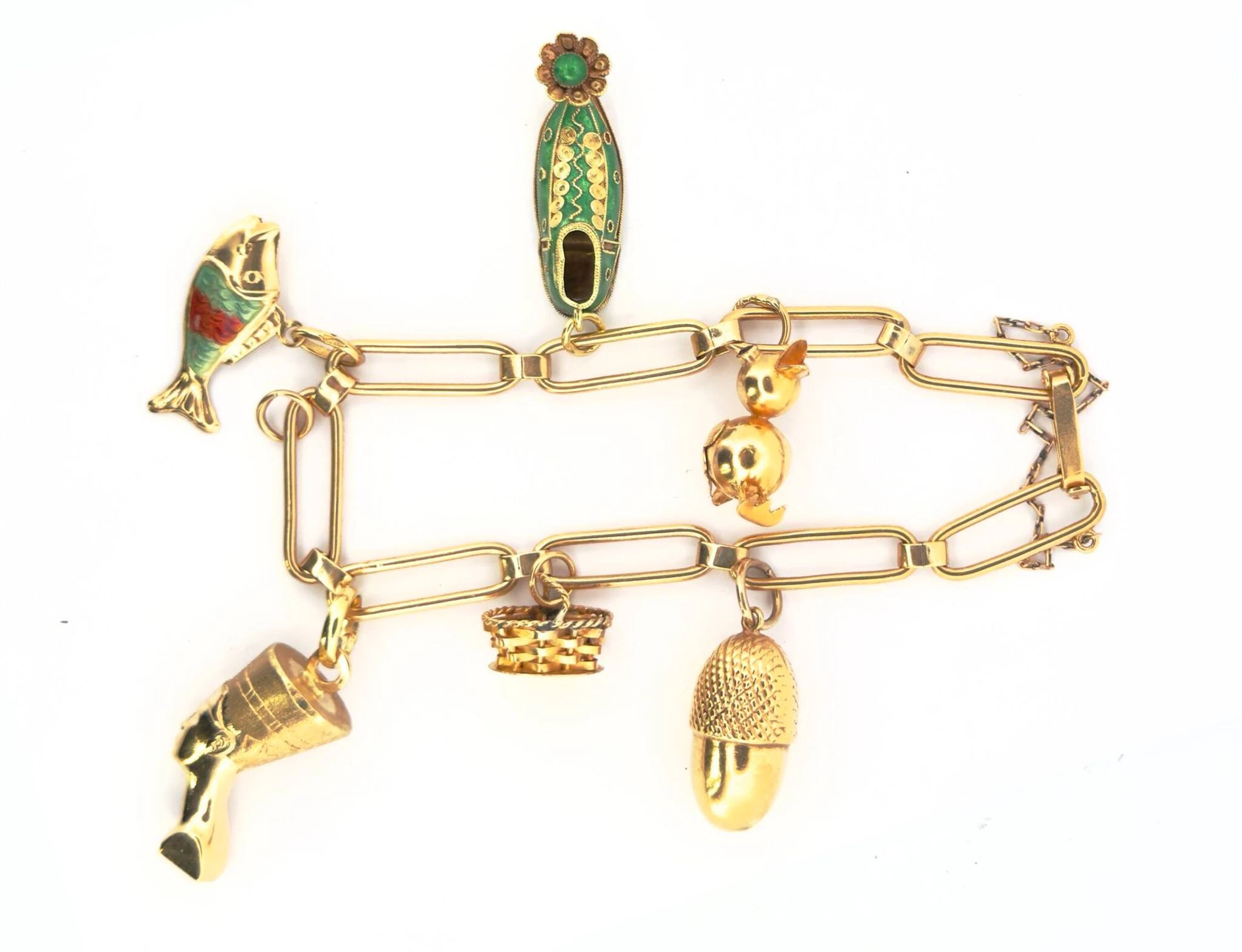 An 18K gold (750) bracelet featuring six 18K gold charms: an - Lot 99