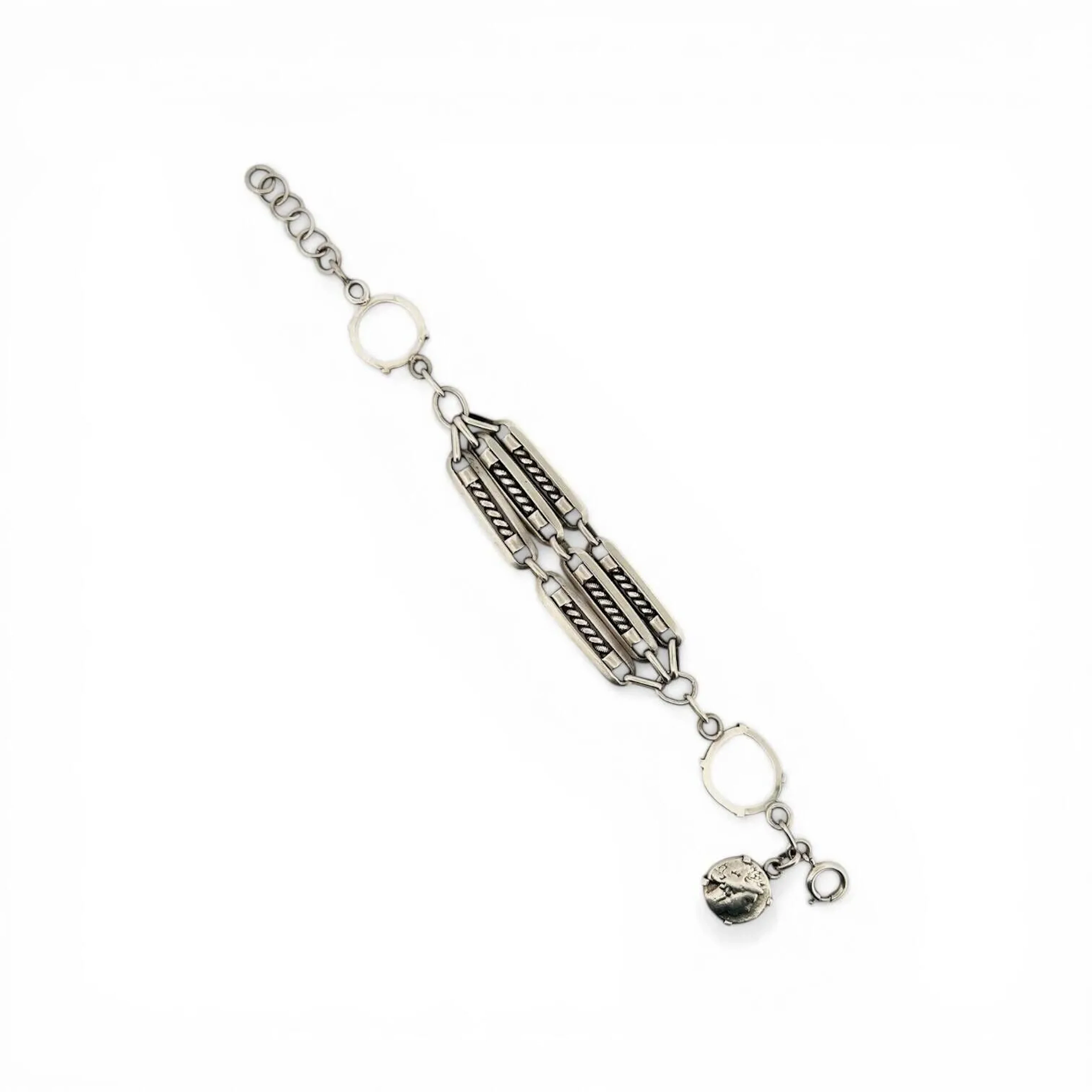Bracelet en argent (800 minimum) formé de six maillons oblongs ajourés à décor torsadé et anciennement serti de pièces de monnaies. Tour de poignet : 19 cm au plus long - Poids : 25.40 g.