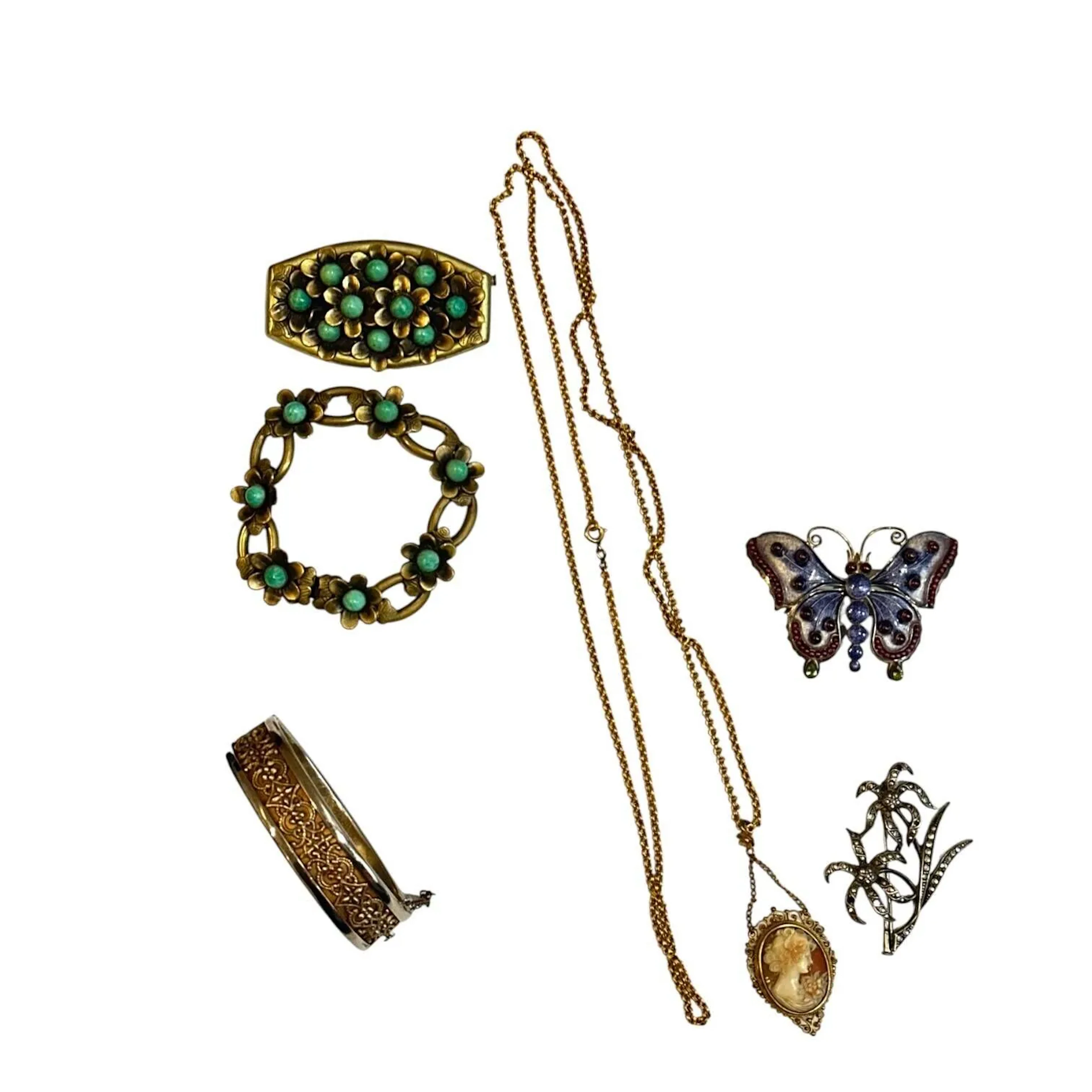Réunion de bijoux fantaisie : - un camée avec une chaîne en métal doré - une demi parure en métal à décor de fleurs composé d'un bracelet et d'une broche - une broche papillon en métal copie d'un modèle des collections du musée des Arts Décoratifs de Paris - une broche fleurs en métal et strass (manques) - un bracelet ruban ouvrant