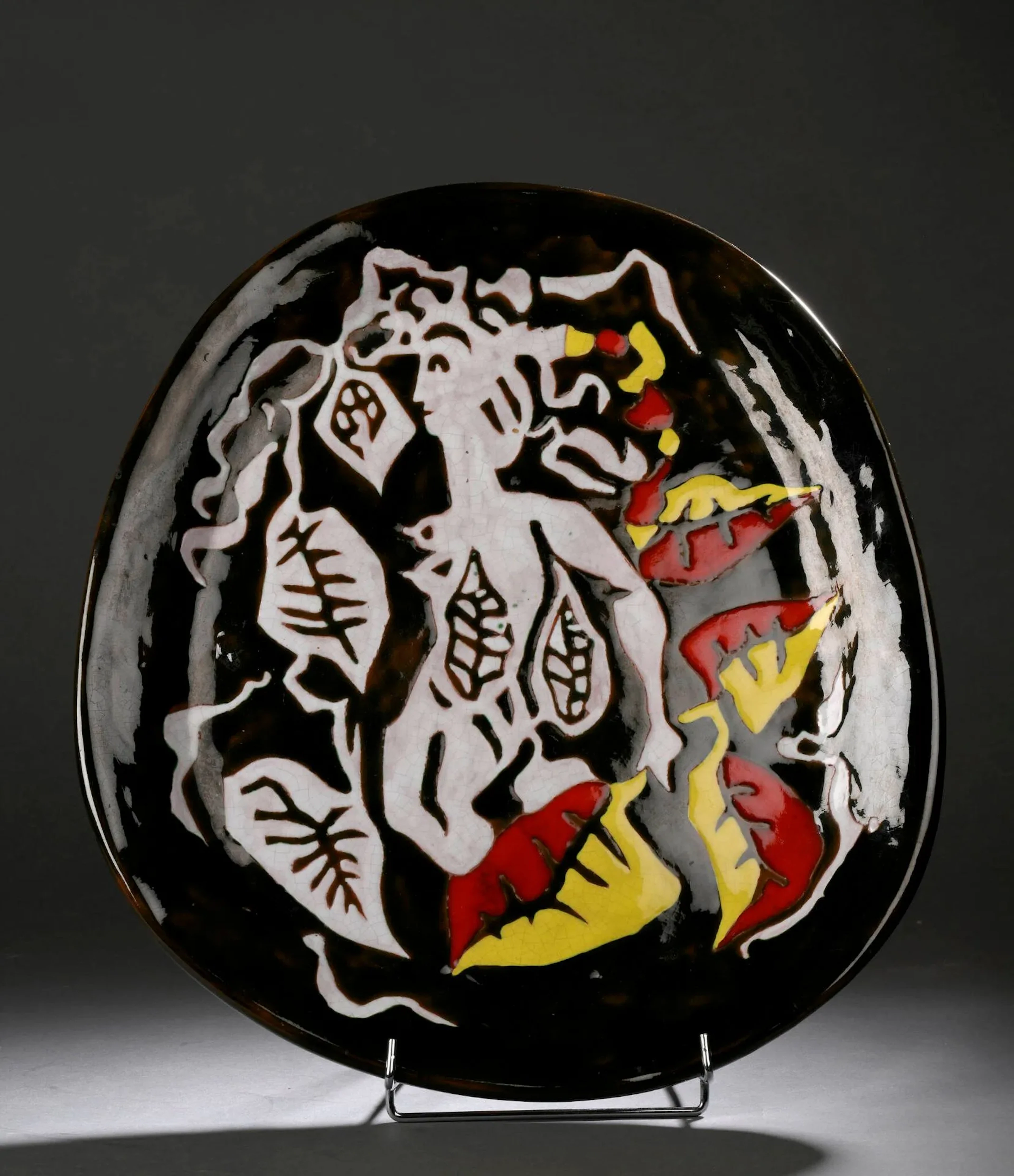 Jean LURÇAT (1892-1966) Important plat, circa 1960 Épreuve en céramique émaillée brun, jaune, rouge et blanc à décor d’une sirène et de feuillages Marquée Dessin J. Lurcat, situé à Sant Vicens et numéroté 21 H sur l’envers. H. : 50 cm. - L. : 45 cm. (Quelques éclats et défauts de cuisson) Atelier Sant Vicens