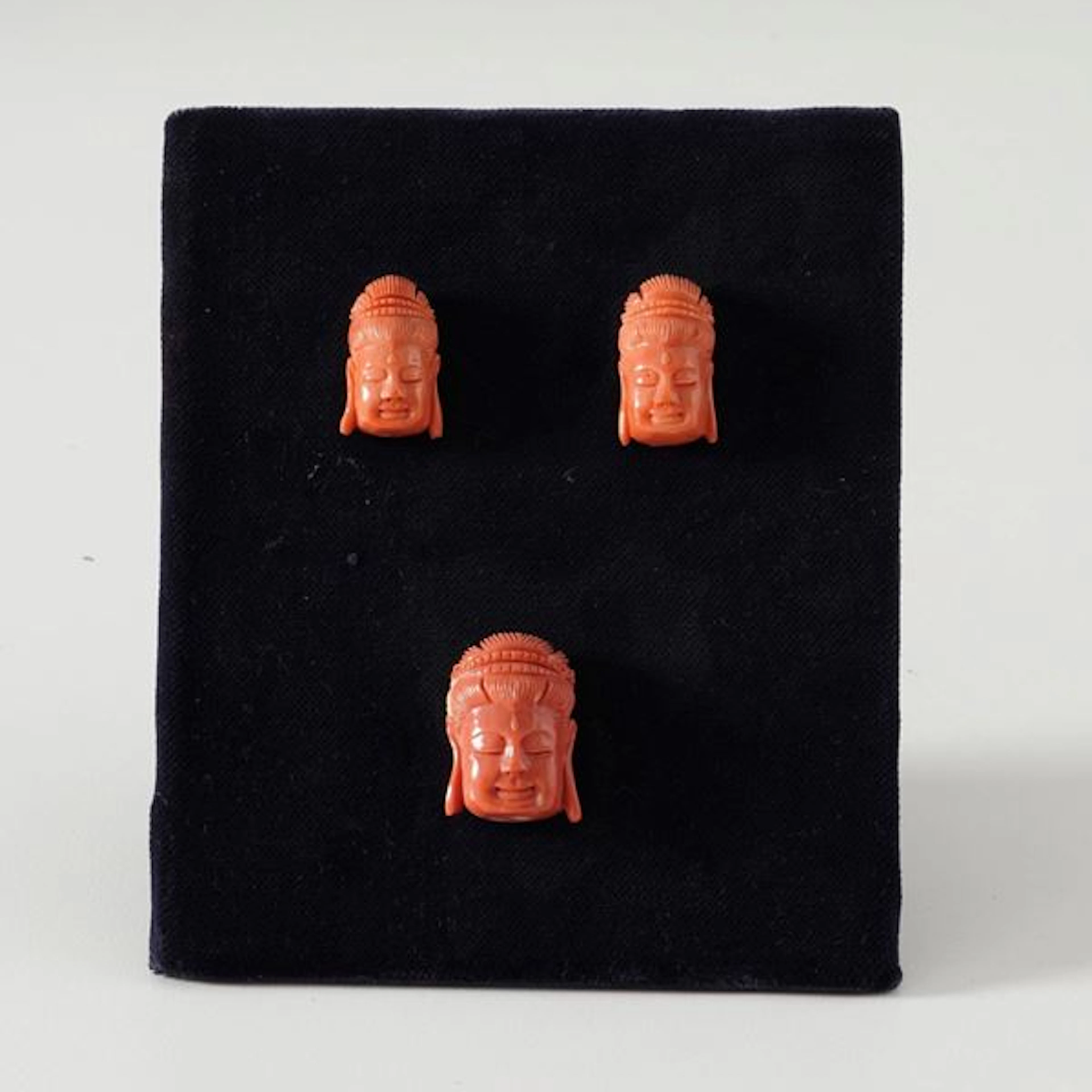 Three coral Buddha heads