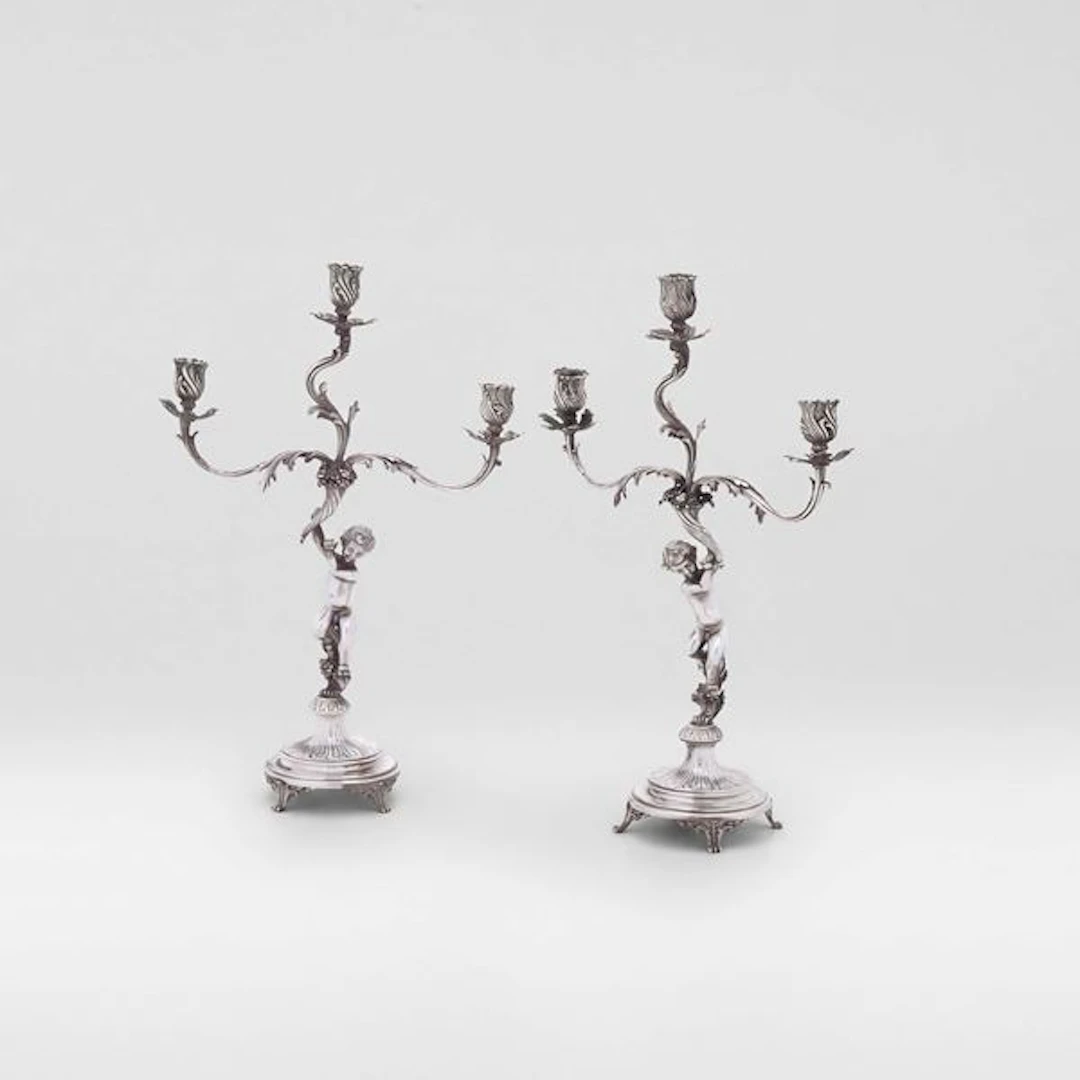 Coppia di candelabri a tre fiamme di gusto neobarocco. Argenteria