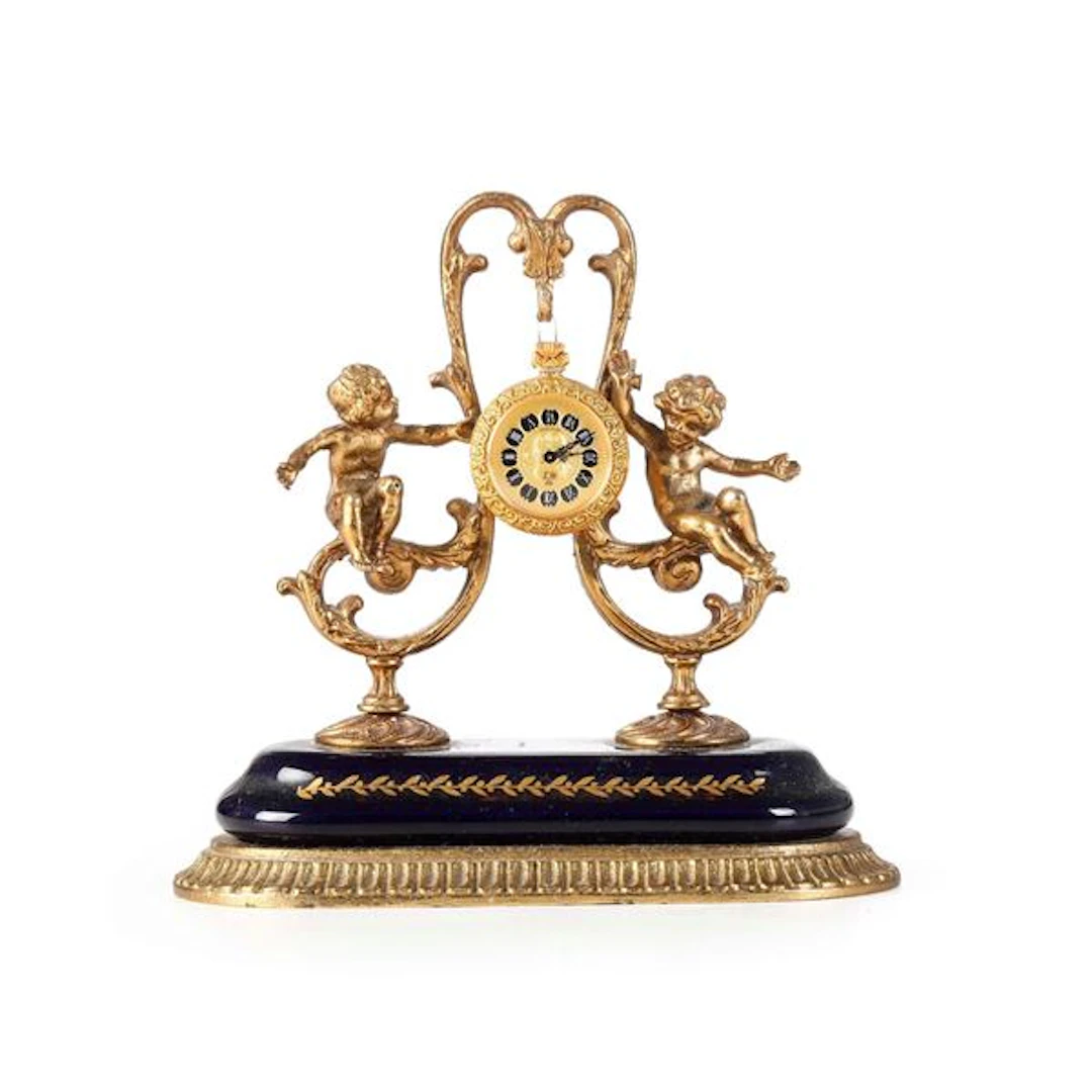 Orologio in metallo dorato e smalti. XX secolo