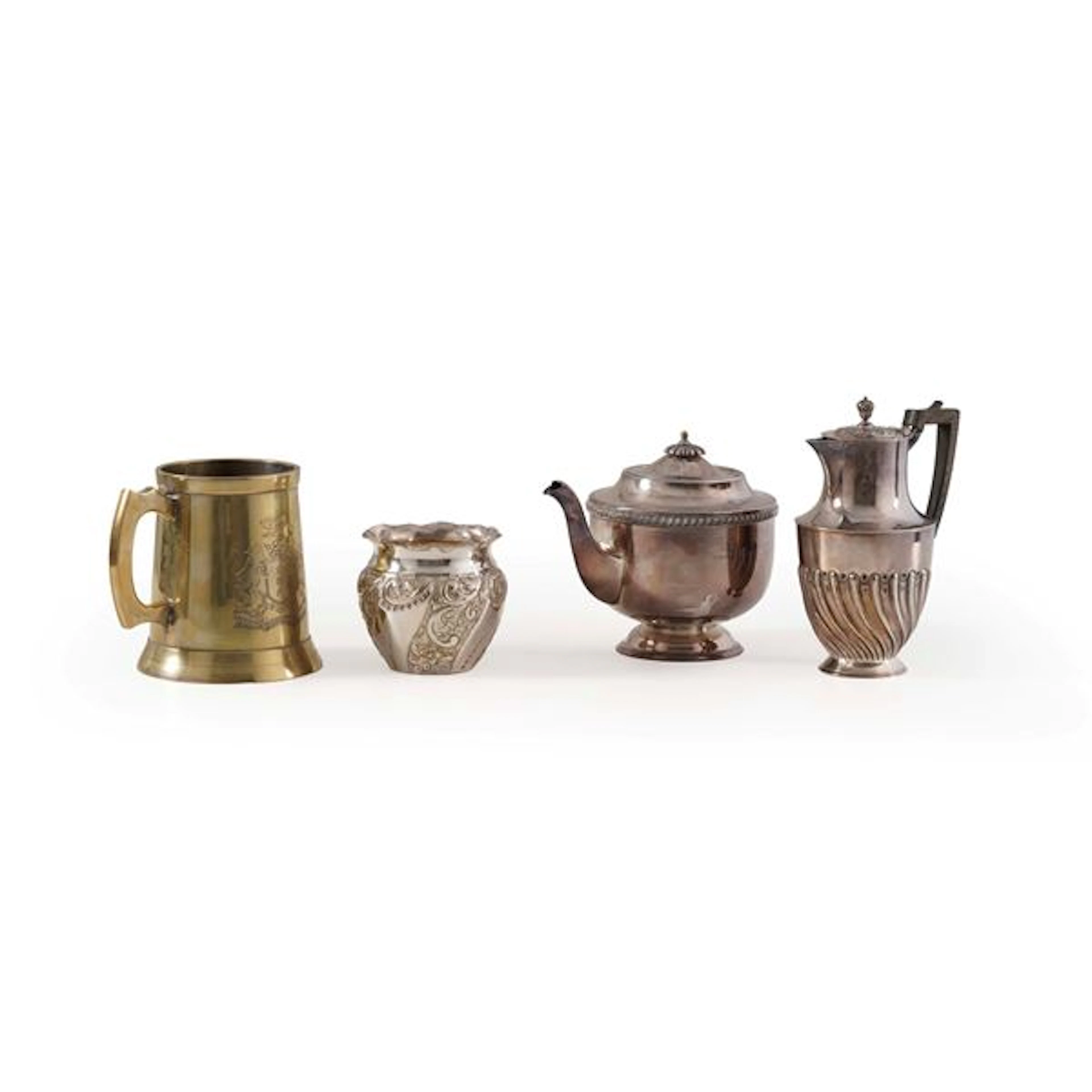Una teiera, una caffettiera un vasetto e un boccale in metallo