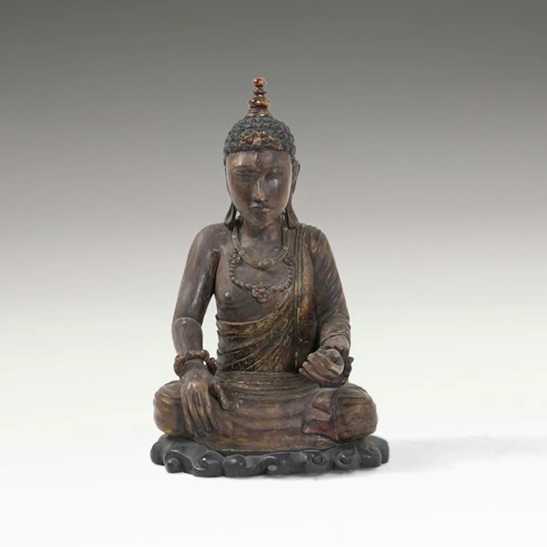 Figura di Buddha in legno con tracce di policromia e collane in materiali