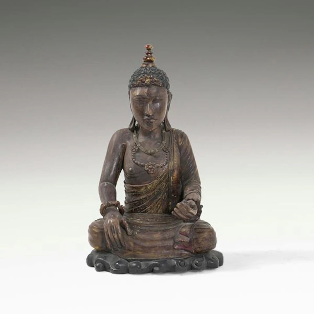 Figura di Buddha in legno con tracce di policromia e collane in materiali