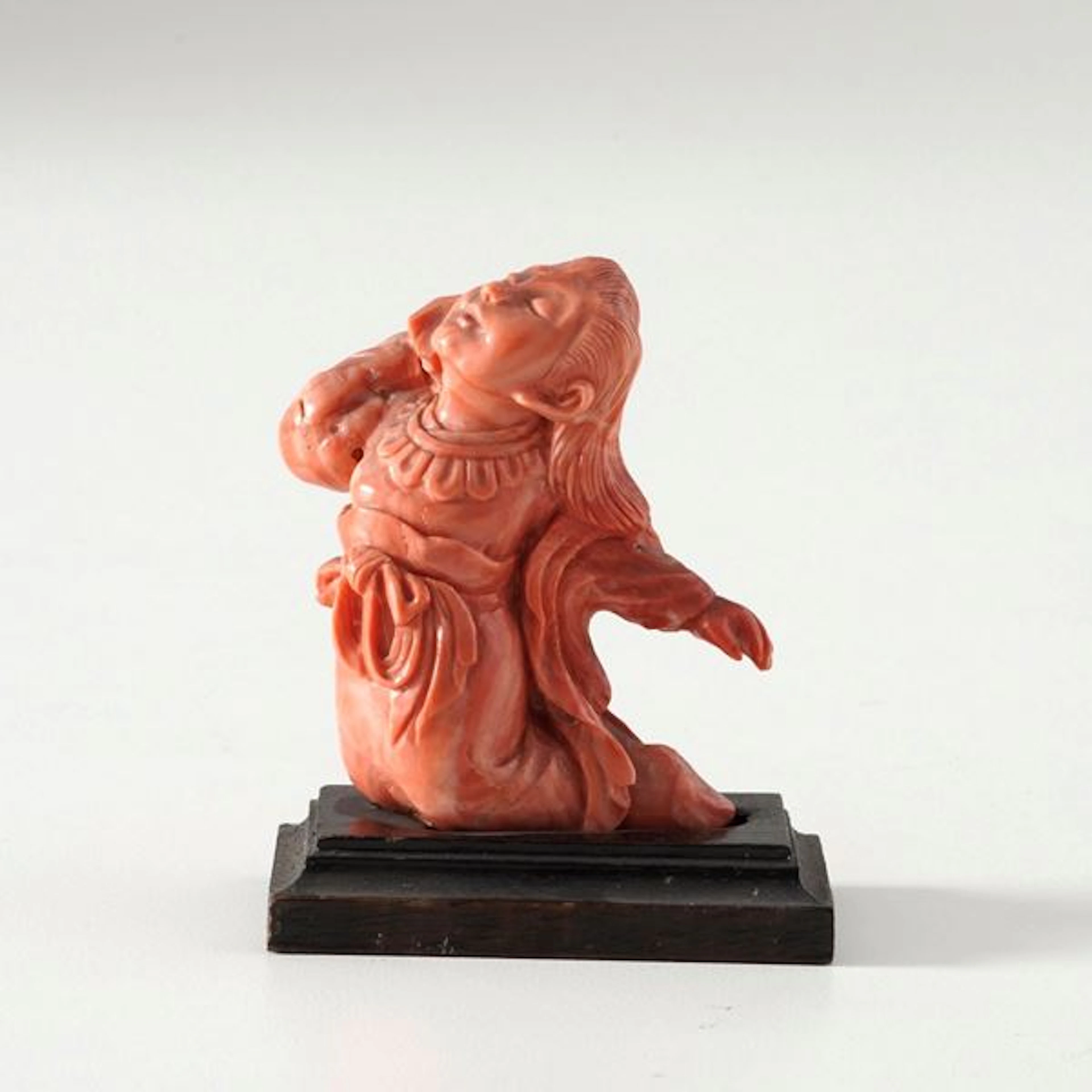 Coral figure of a kneeling young man