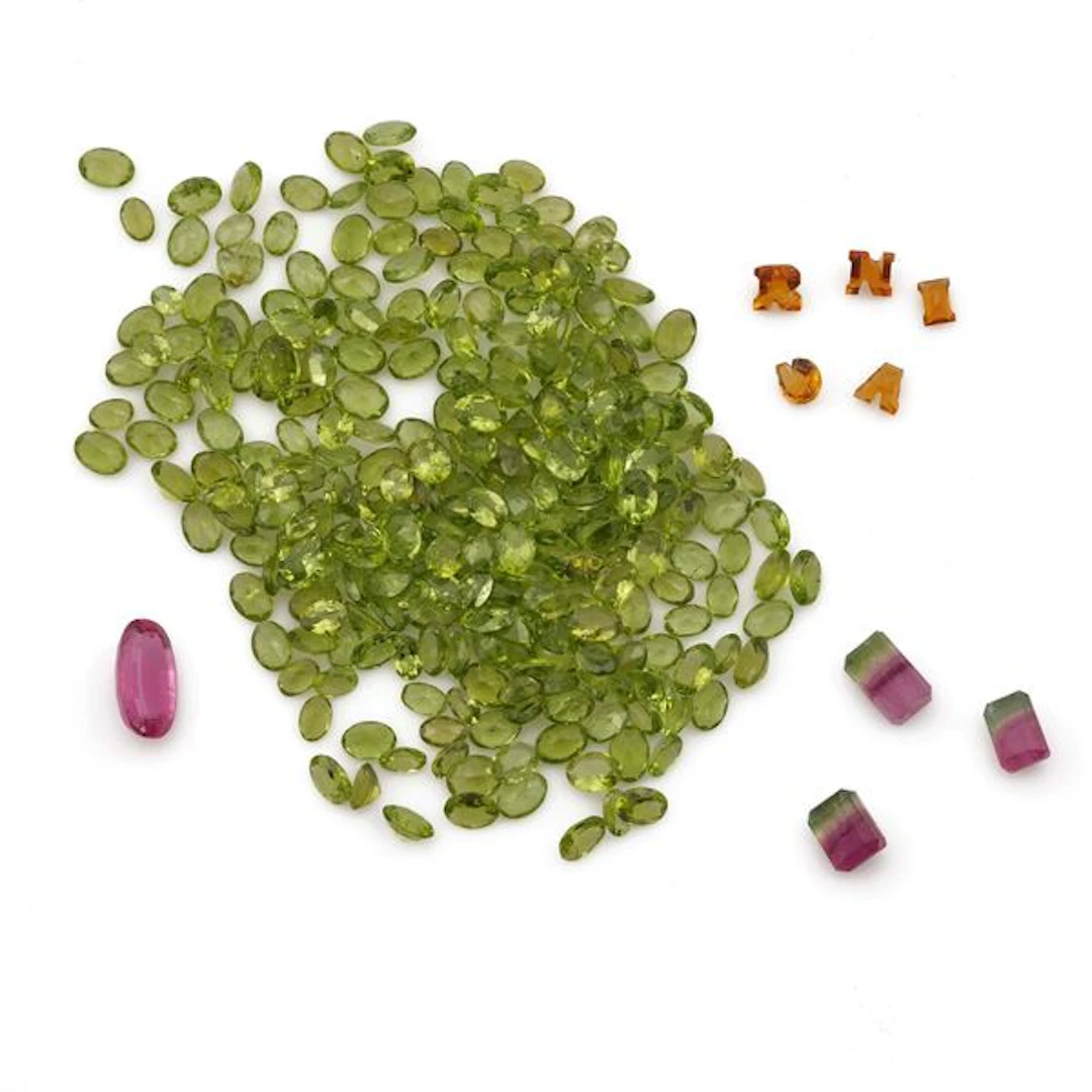 Collection of unmounted gemstones, including amethysts, peridots and
