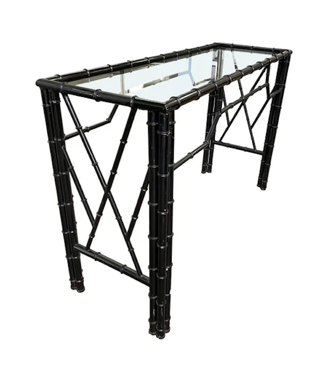 A 1960s faux bamboo black lacquered console table with glass shelf