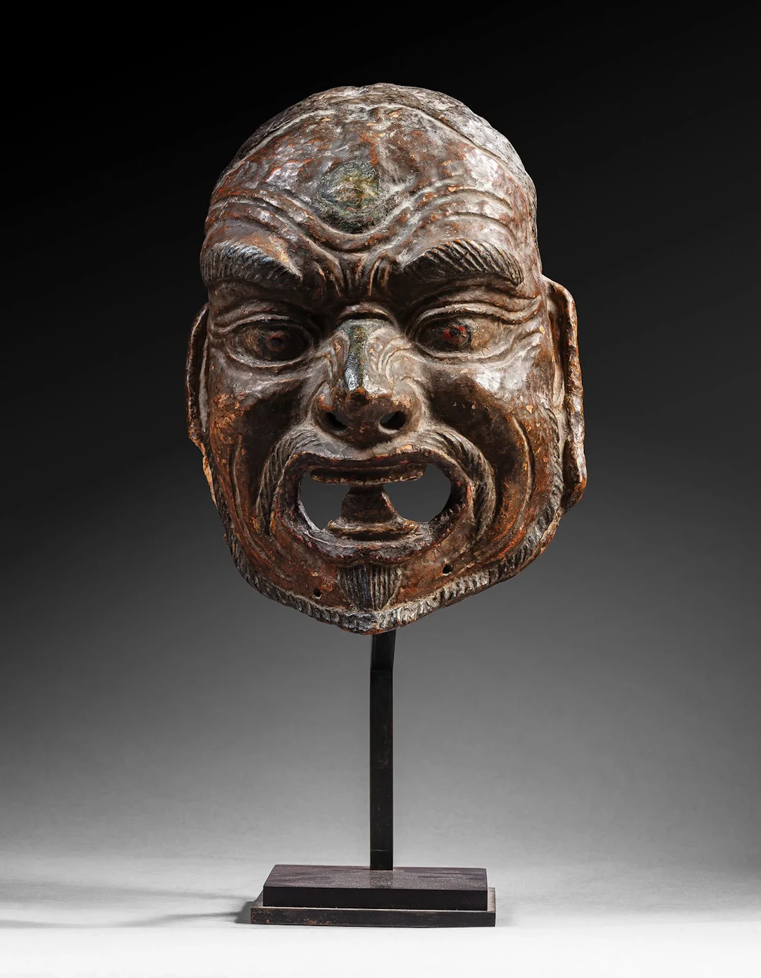 Polychrome papier-mâché mask depicting the face of an angry - Lot 179