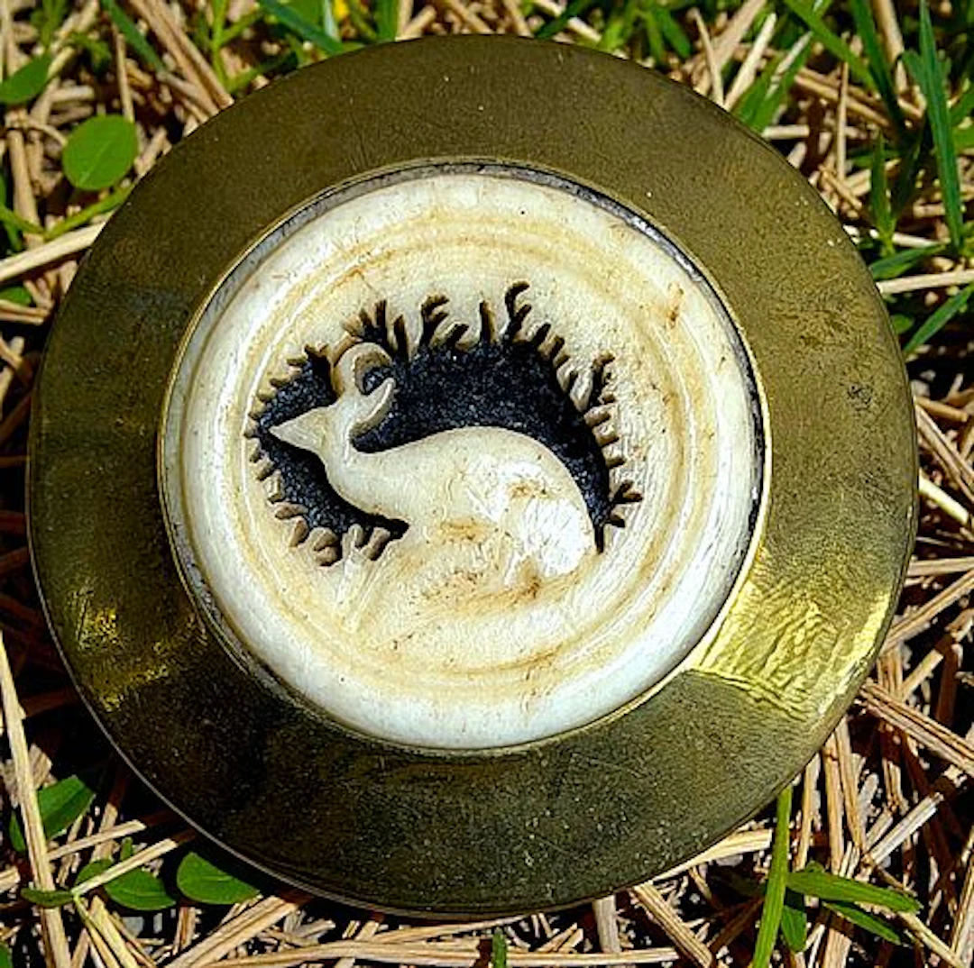 A DIVISION ONE CARVED ANIMAL SET IN METAL BUTTON