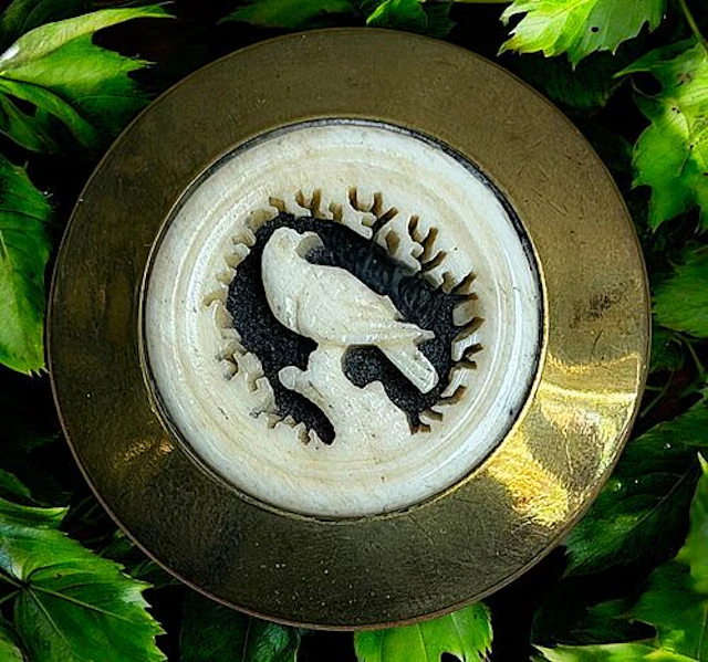 A DIVISION ONE CARVED ANIMAL SET IN METAL BUTTON