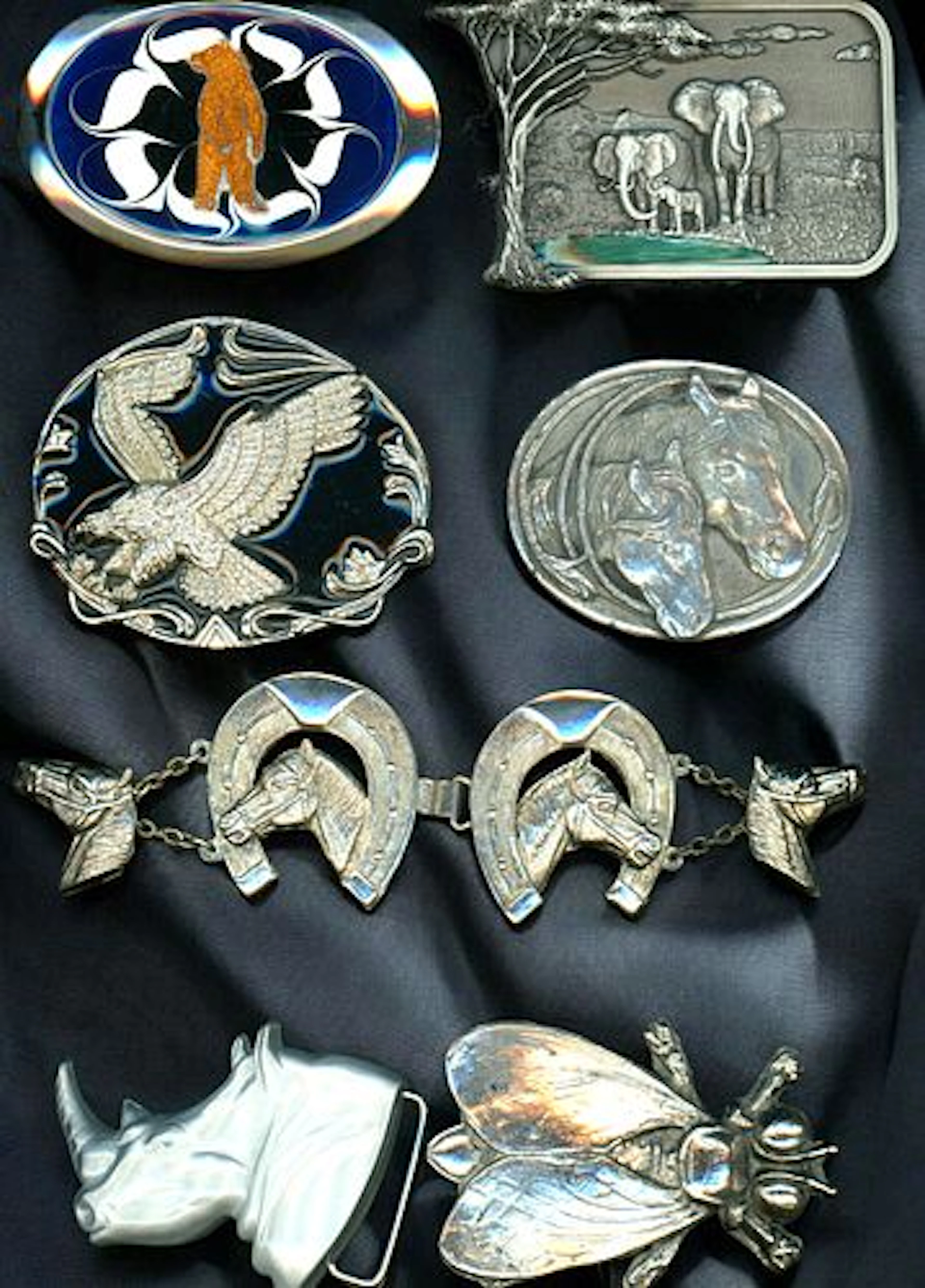 A CARD OF ASSORTED WHITE METAL BUCKLES