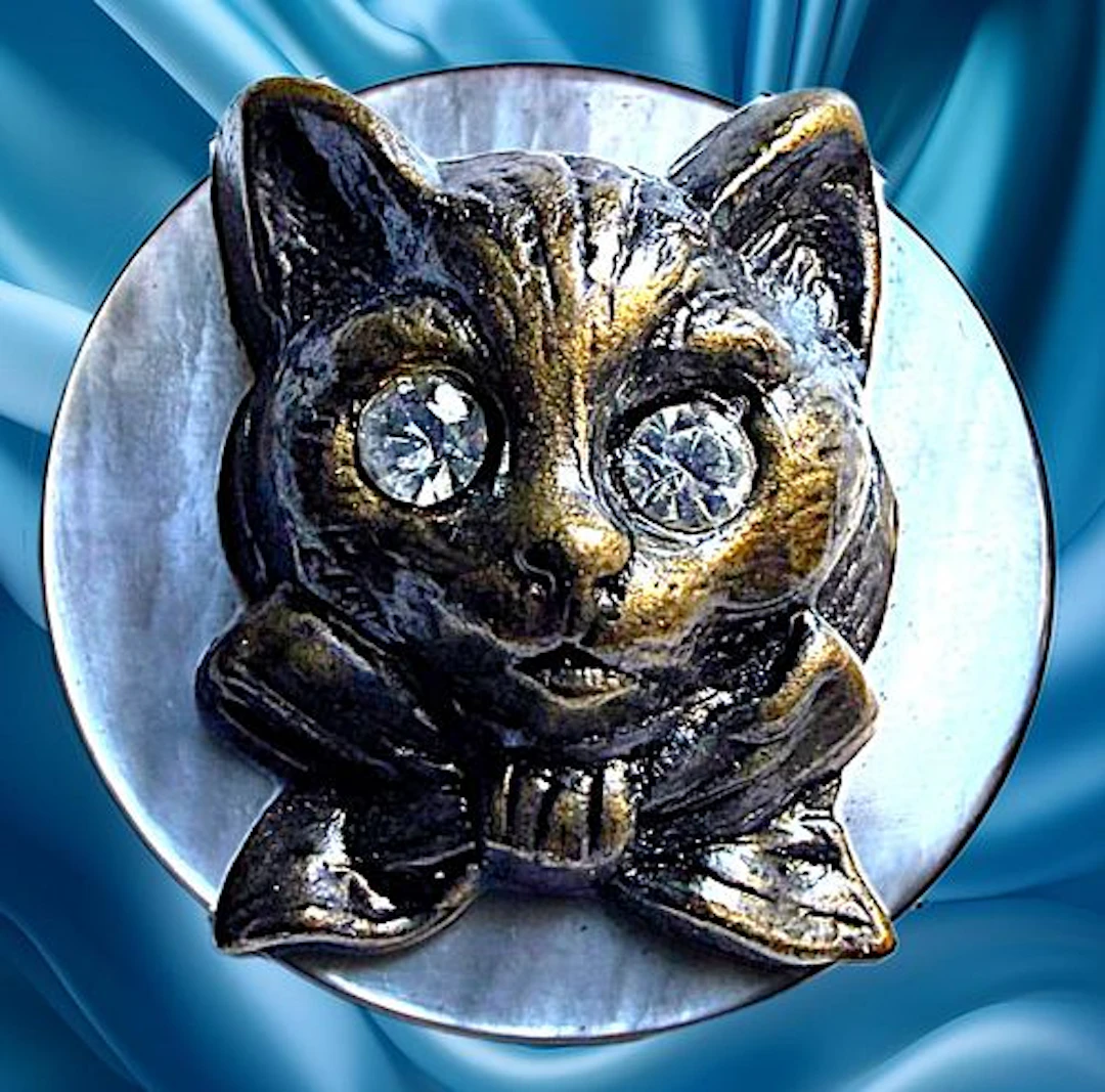 A DIVISION ONE PEARL AND BRASS ANIMAL BUTTON