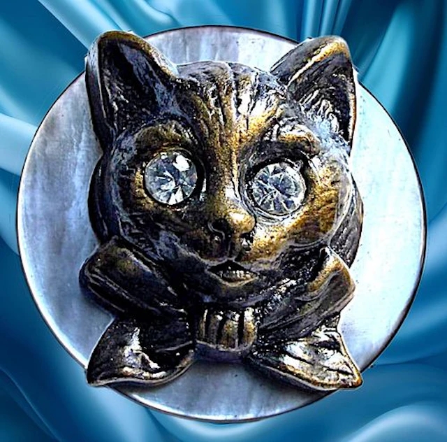 A DIVISION ONE PEARL AND BRASS ANIMAL BUTTON