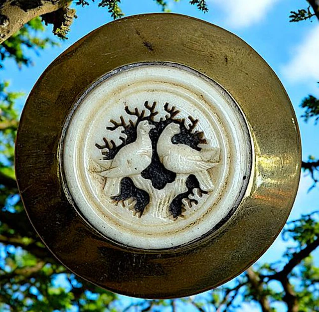 A DIVISION ONE CARVED ANIMAL SET IN METAL BUTTON