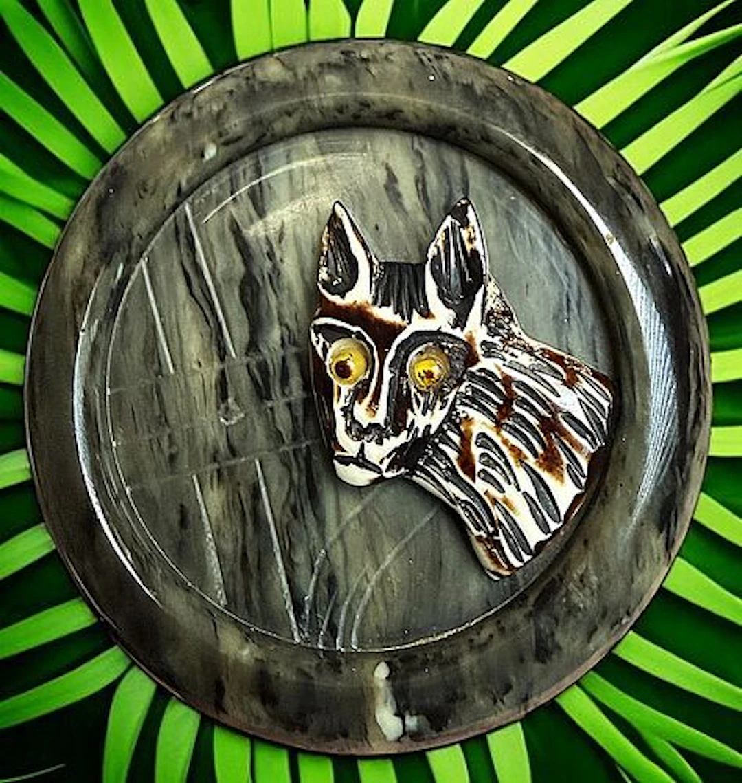 A DIVISION ONE CASEIN CARVED CAT BUTTON