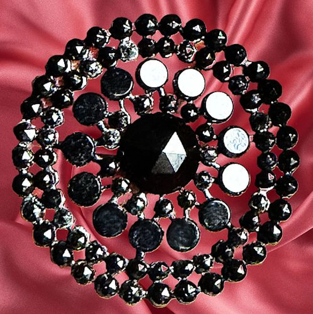 A DIVISION ONE PIERCED RIVETED BLACK GLASS BUTTON