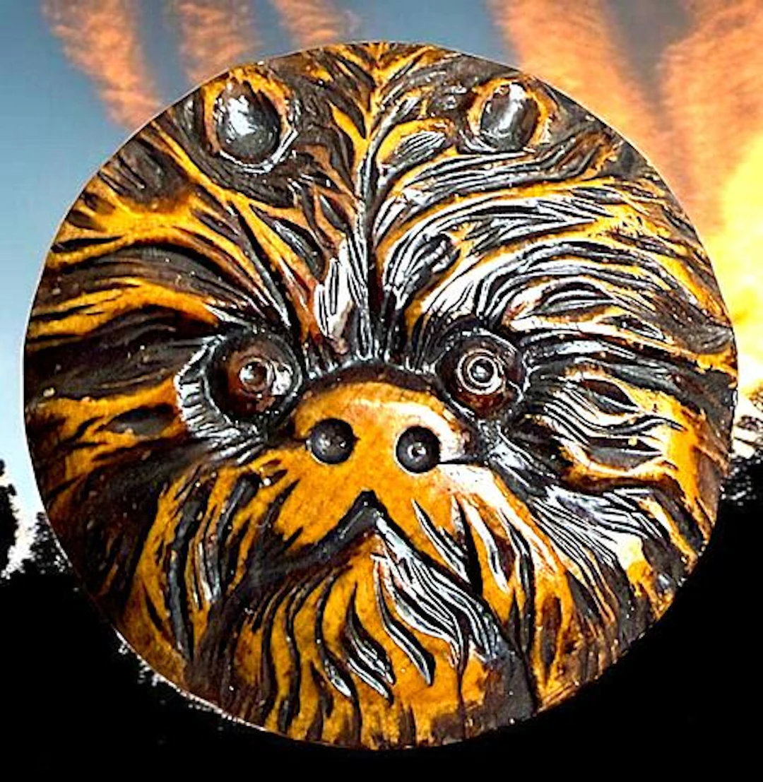 A DIVISION ONE CARVED WOOD PICTORIAL BUTTON