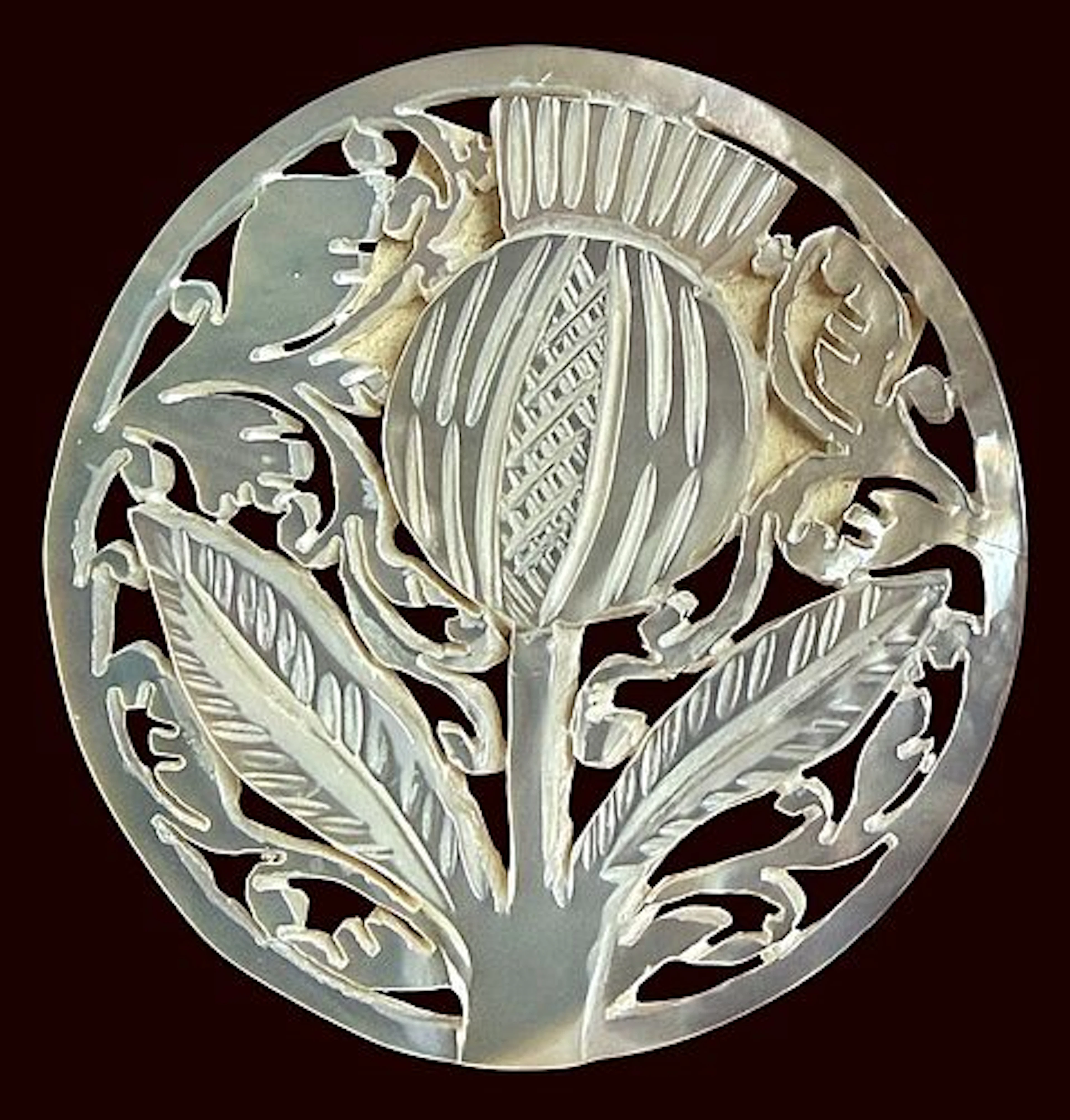 A DIVISION THREE CARVED PEARL PICTORIAL BUTTON