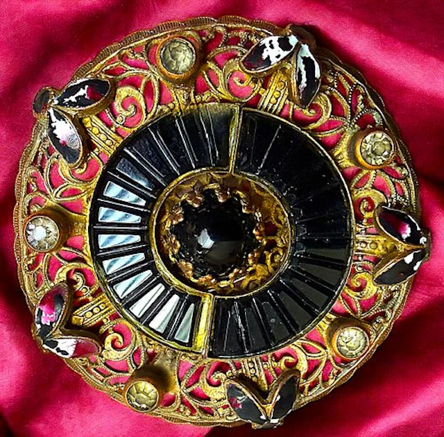 A DIVISION ONE BLACK GLASS IN ORNATE METAL BUTTON